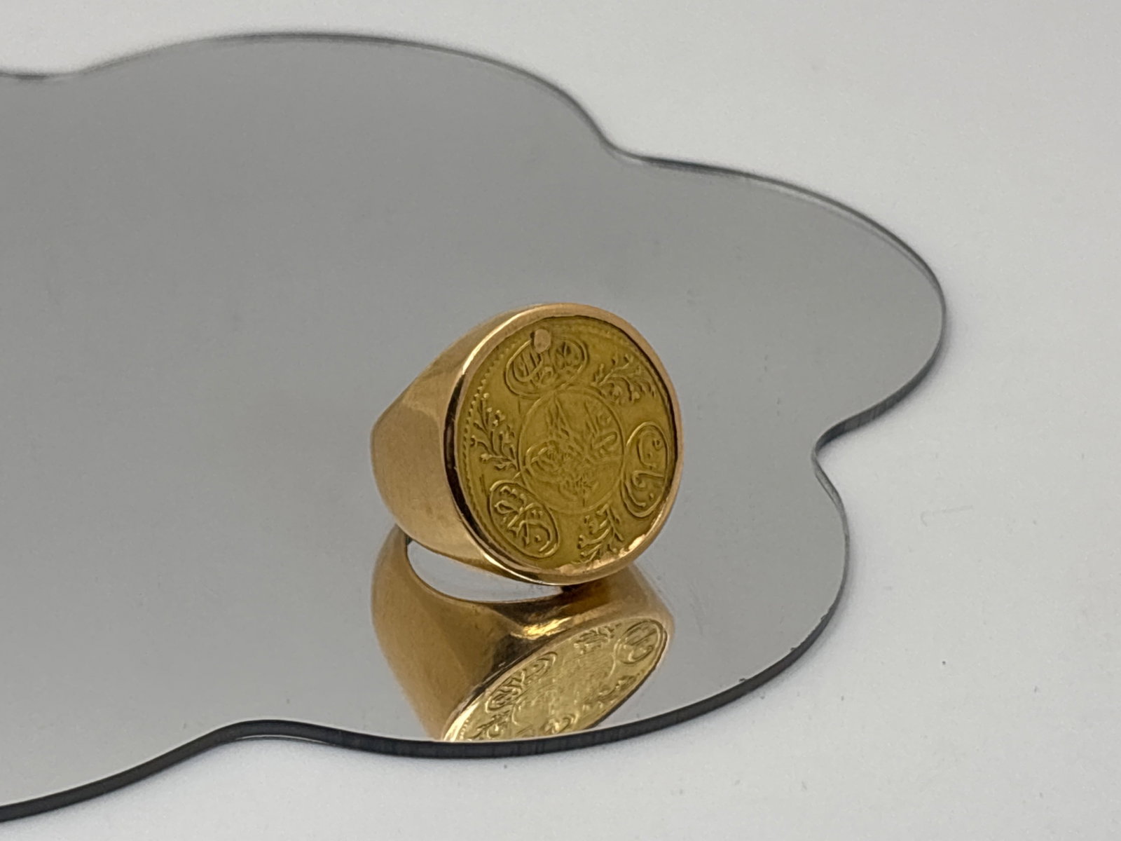 18K Ring with Turkish Ottoman Gold Coin: A substantial 18K yellow gold band set with an Ottoman coin mounted on a thin planchet. The band shows remnant Egyptian hallmarks slightly visible on the interior. Ring size 5. 5.35 dwt. Coins shows