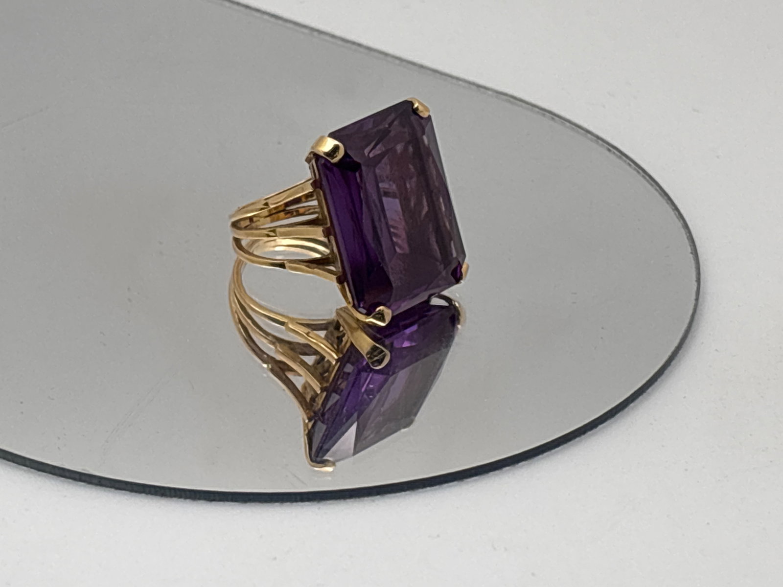18K Color Change Sapphire Cocktail Ring: A statement cocktail ring featuring an over 13 ct radiant-cut color change sapphire of 11.8 mm x 16.8mm in an 18K yellow gold raised filigree setting with Egyptian hallmarks. Ring size 4.5. 8.69 dwt.