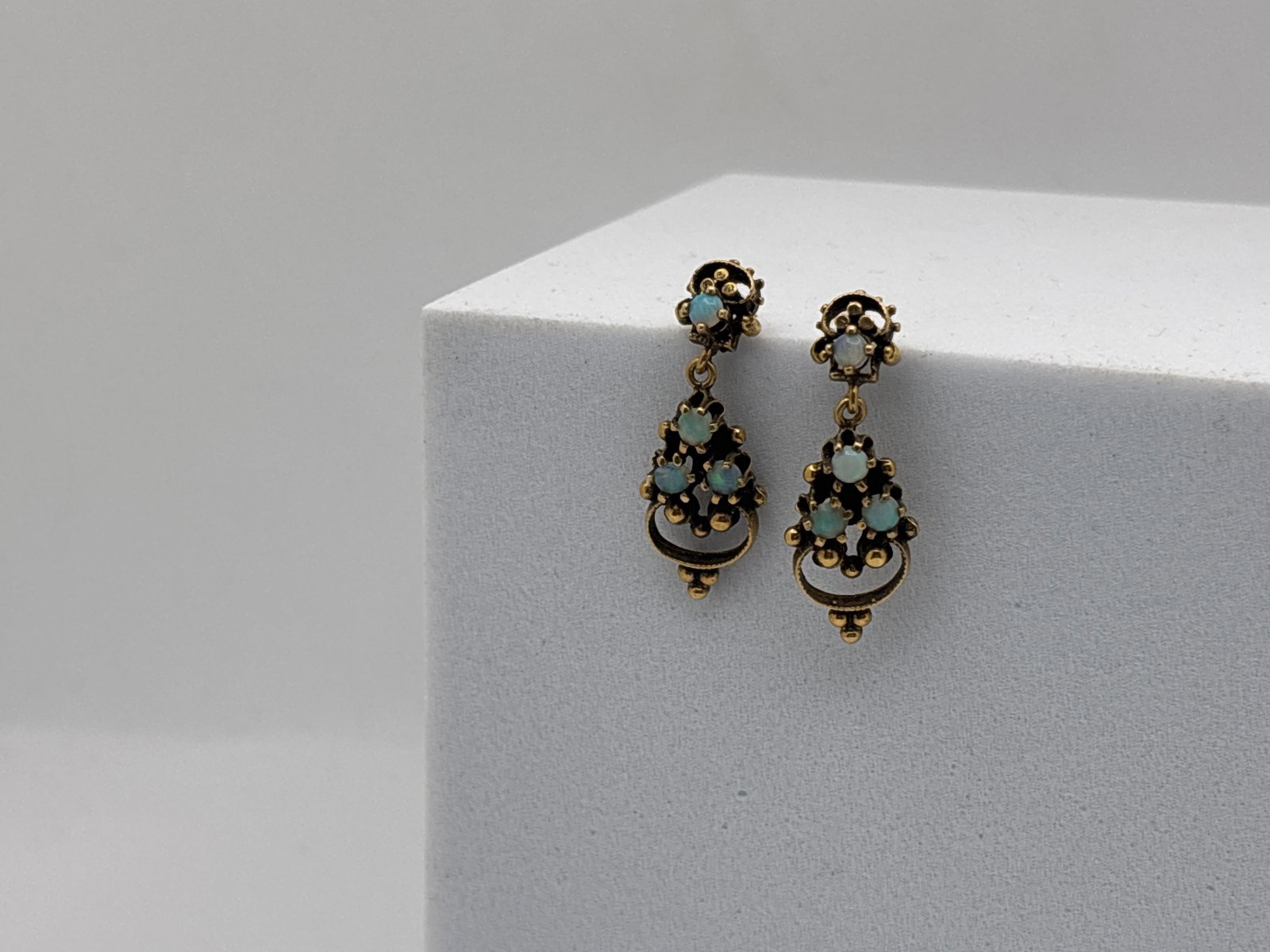 14K Yellow Gold Etruscan Revival Opal Earrings: A pair of 14K yellow gold (tested) filigree pierced Etruscan revival drop earrings, each set with four 3.4mm opal cabochons. 1-1/4in long. 3.09 dwt. | You have additional shipping options, and are