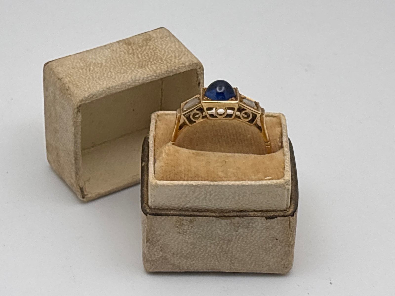 14K Sapphire and Diamond Ring: A 14K yellow gold (tested) ring featuring a 5.7mm sapphire cabochon flanked by rose cut diamonds of 2.9mm each, in a squared filigree setting. Ring size 8. 1.92 dwt. | You have additional shipping