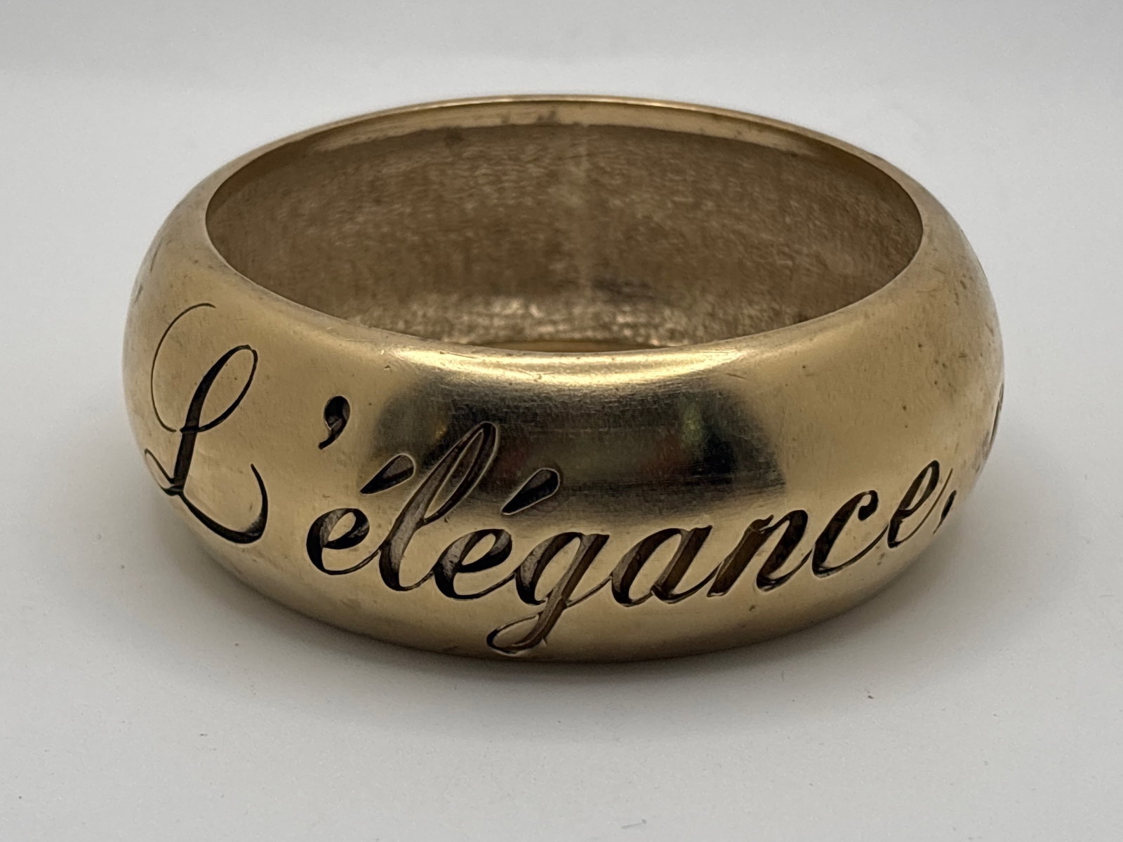 2007 Chanel L'Elegance C'est La Ligne Bangle Bracelet: A Chanel gold-tone bangle bracelet with engraved phrase surround, named "L'Elegance C'est La Ligne" (Elegance is the line), a philosophy and quote attributed to Coco Chanel. Marked Coco Chanel, dated 