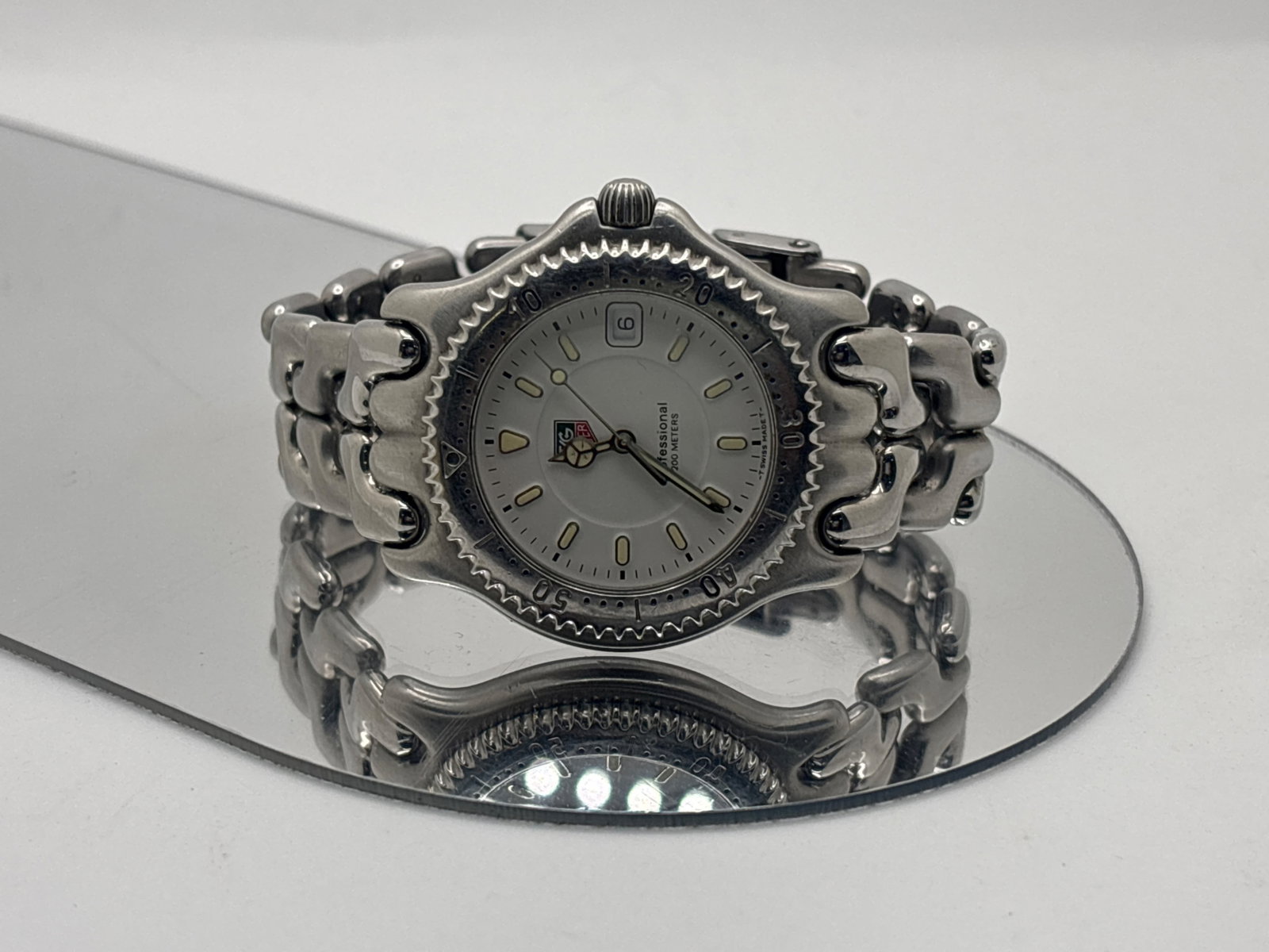 Tag Heuer Professional WG1112-KO: A stainless steel Tag Heuer wristwatch joined on original stainless steel band with flip lock buckle. White dial and indices. 39.8mm case, 6-7/8 inner length. | You have additional shipping options,