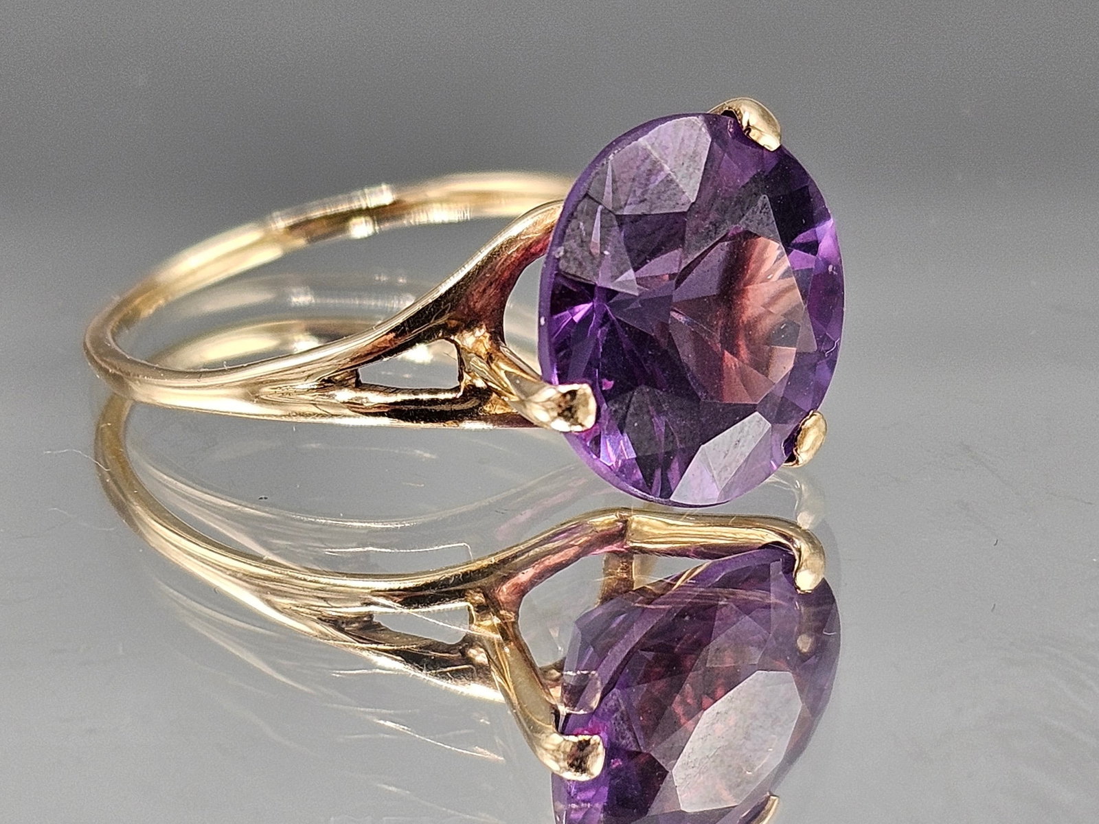 14K Ring with Color-Changing Sapphire Ring: A 14K yellow gold solitaire ring with open work mounting set with a round, brilliant cut color-changing sapphire. Marked 14K. Size 8-3/4. 2.50 dwt. | You have additional shipping options, and are not 