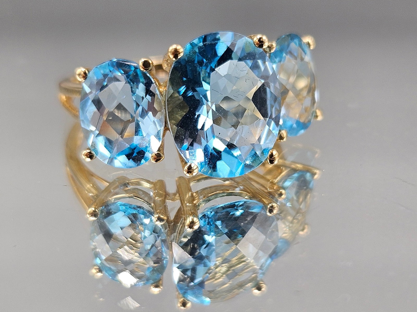 14K Yellow Gold Ring with Three Blue Topaz: A 14K yellow gold ring with three oval cut blue topaz stones. Marked 14K. Size 8. 3.02 dwt. | You have additional shipping options, and are not required to use Live Shipping. Additional shipping and d