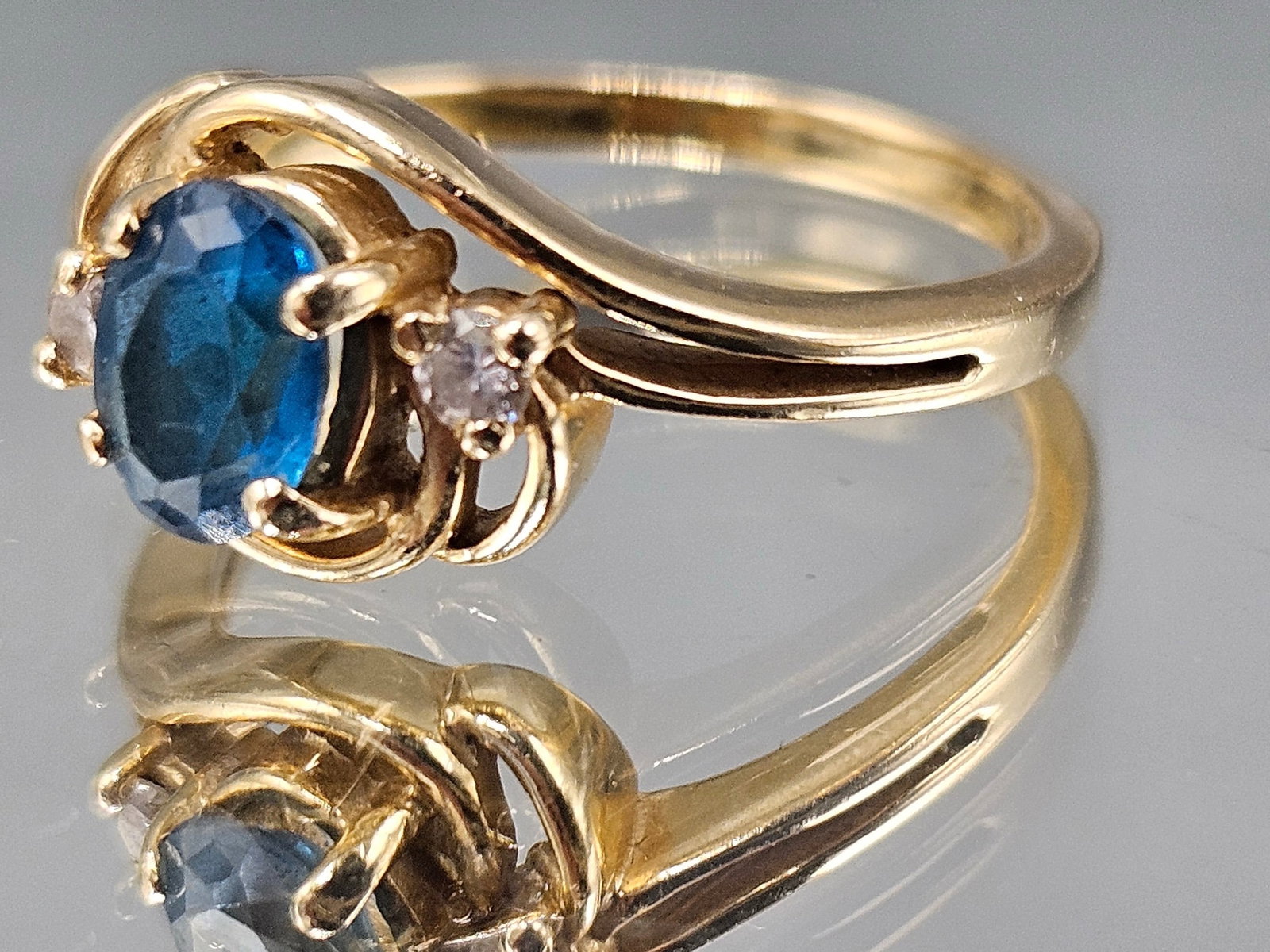 14K Yellow Gold Ring with Blue Topaz and Diamonds: A 14K yellow gold ring with an oval cut blue topaz flanked by two small diamonds. Marked 14K. Size 7-1/2. 2.5 dwt. | You have additional shipping options, and are not required to use Live Shipping. Ad