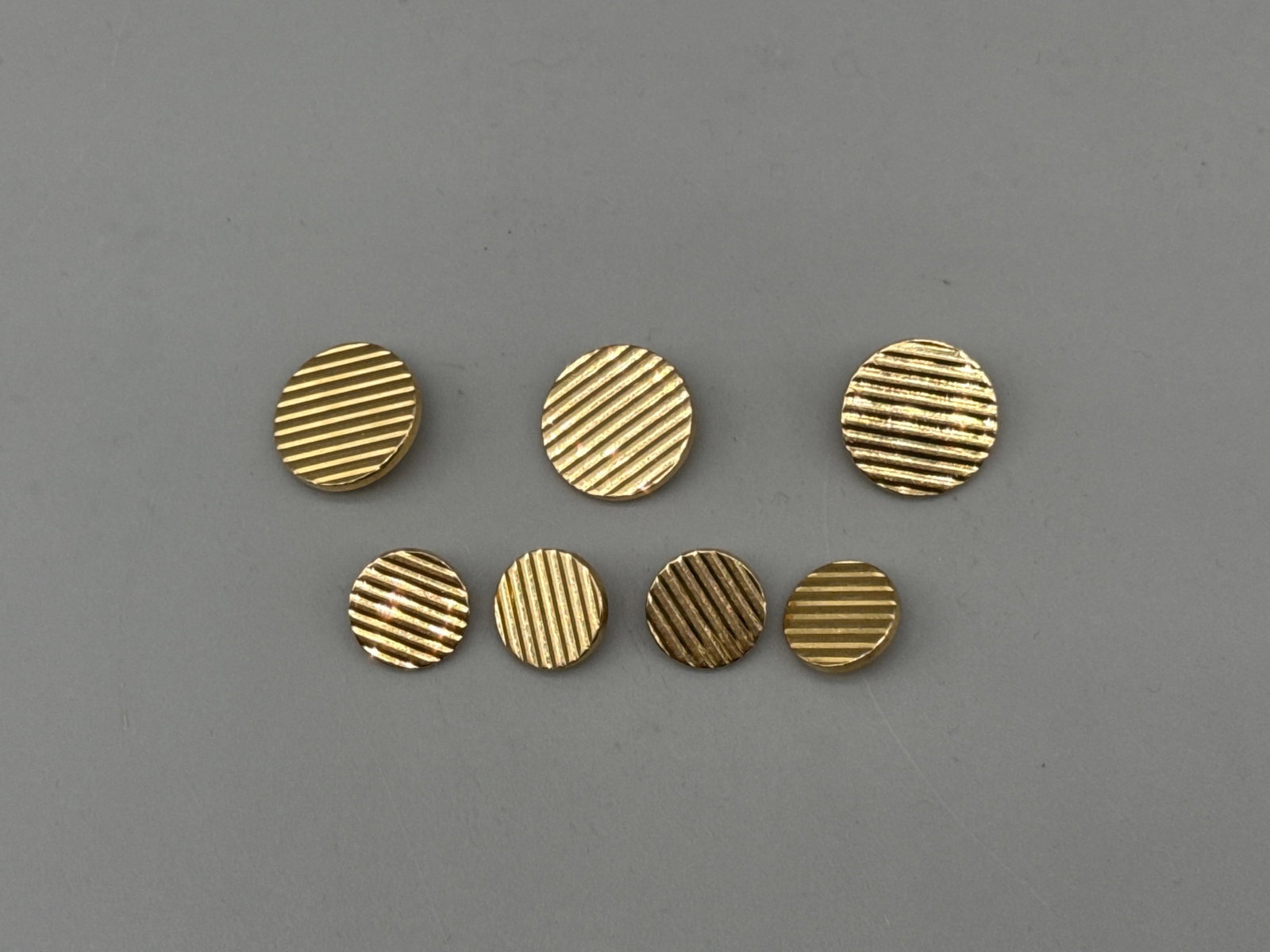Tiffany & Co. 14K Yellow Gold Cufflinks and Tie Tacks: Tiffany & Co. 14K yellow gold cufflinks and four tie tacks, all with distinct striped design. Marked Tiffany & Co 14K. Larger: 1-3/4in diameter. 25.65 dwt. | You have additional shipping options, and 