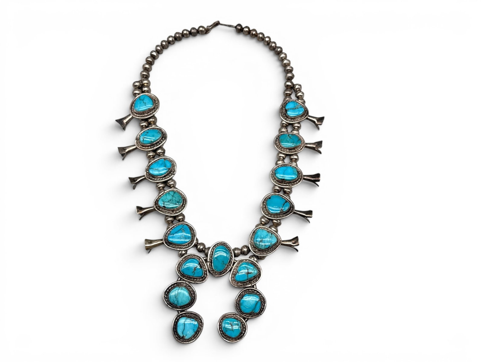 Navajo Silver Turquoise Squash Blossom Necklace: A Navajo silver squash blossom necklace with turquoise stones and Navajo pearl beads. Necklace: 20in long. Naja: 3in tall x 3in wide. 110.66 dwt. | You have additional shipping options, and are not re