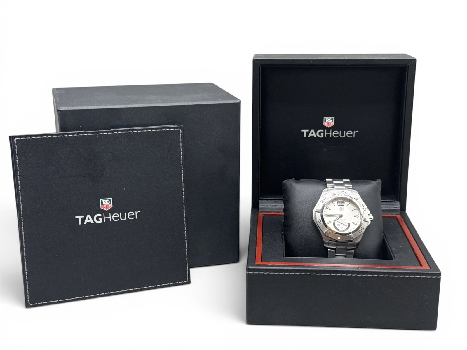 Tag Heurer Aquaracer Grande Date Watch: A Tag Heurer Aquaracer Grande Date Watch with stainless steel band, rotating bezel, and scratch-resistant sapphire crystal. Includes original box with paperwork. Band: 5in diameter. | $1000-3000. | Yo