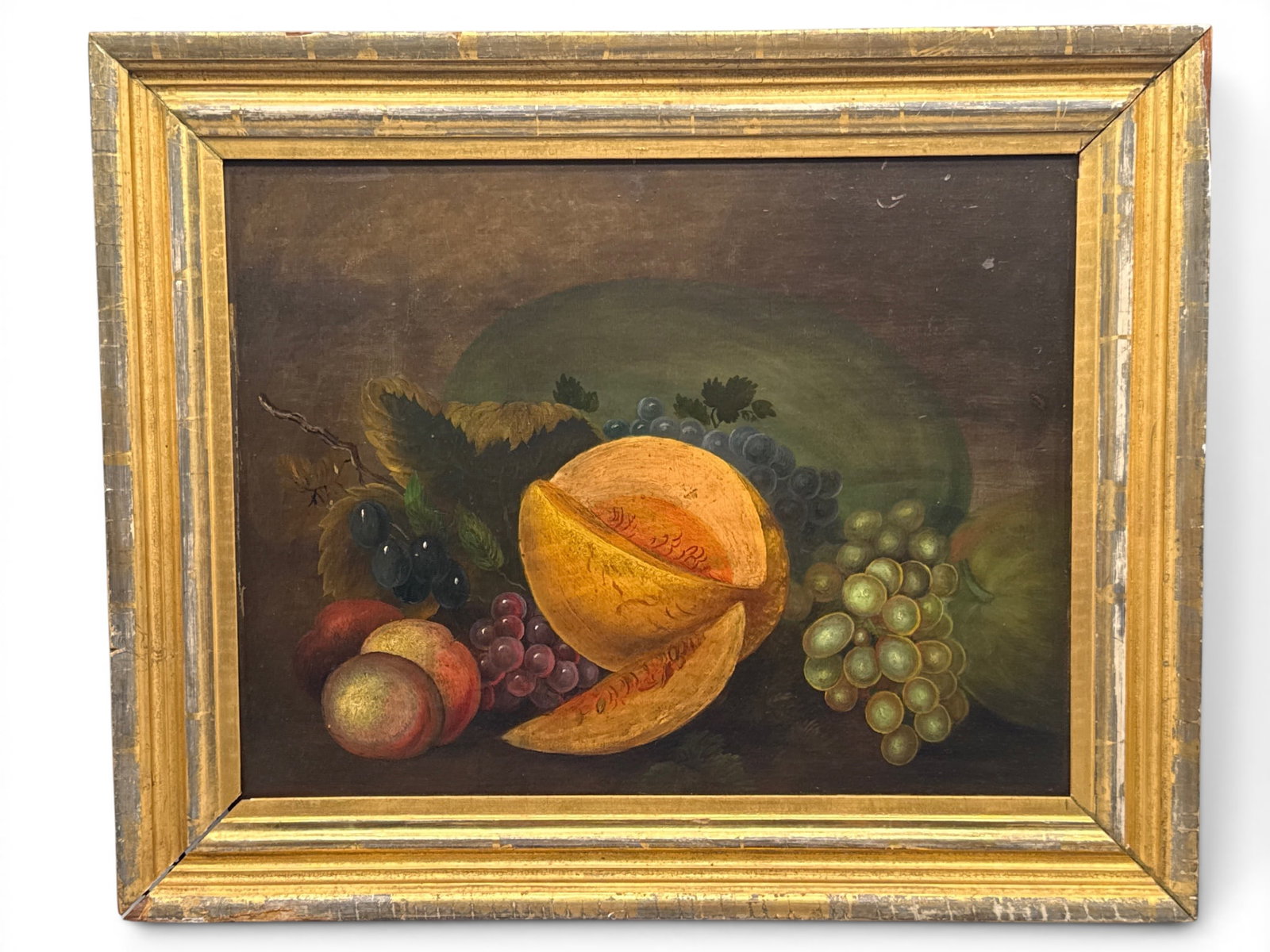 Gilt-Wood Framed Oil/Board: Fruit Still Life: A gilt-wood framed oil on board depicting a fruit still life comprised of melon, peaches and grapes. Board: 14in x 18in. Frame: 19in x 23in. | You have additional shipping options, and are not require