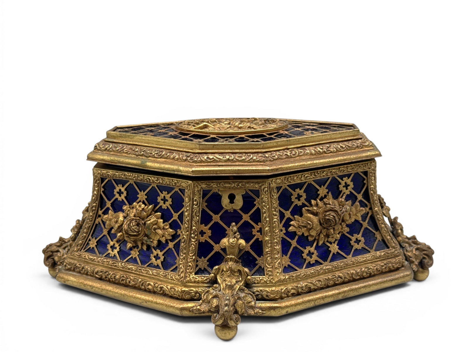 French Bronze Filigree Cobalt Glass Jewelry Casket: A French bronze-cased casket with romantic genre scene at center, filigree and floral decoration, inset cobalt blue glass, and applied bronze swag. Interior features cobalt blue velvet lining. 5in tal