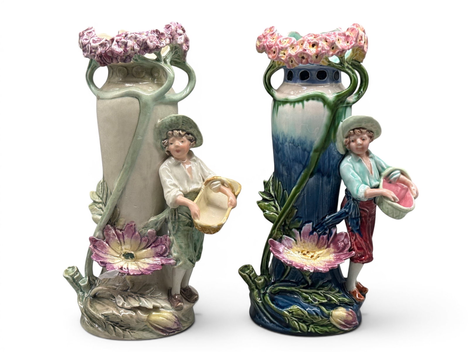 Two T.C. Brown Art Nouveau Majolica Figural Vases: Two Art Nouveau majolica vases with figures holding baskets surrounded by large stylized flowers. Each signed T.C. 13in tall x 6in wide. | You have additional shipping options, and are not required to