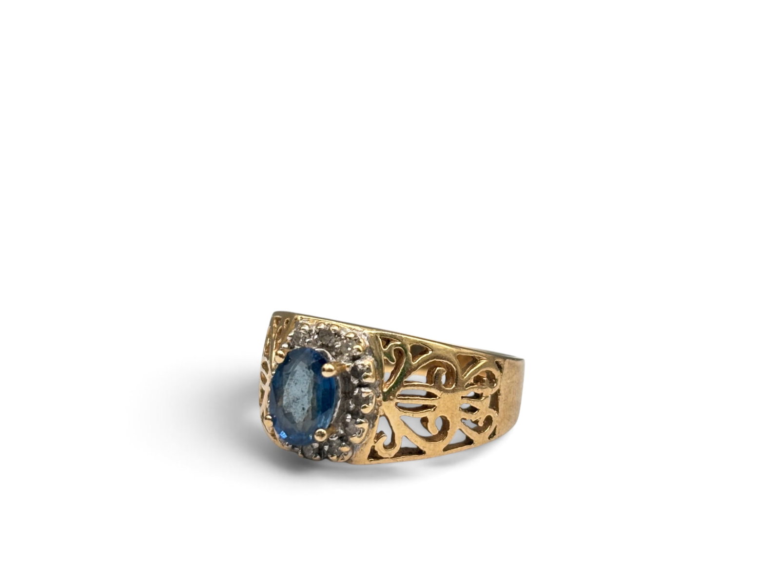 14K Blue Topaz and Diamond Openwork Ring: A 14K yellow gold ring with openwork shoulders set with a central oval cut blue topaz surrounded by diamonds. Marked 14K. Size 8. 3.08 dwt. | You have additional shipping options, and are not required