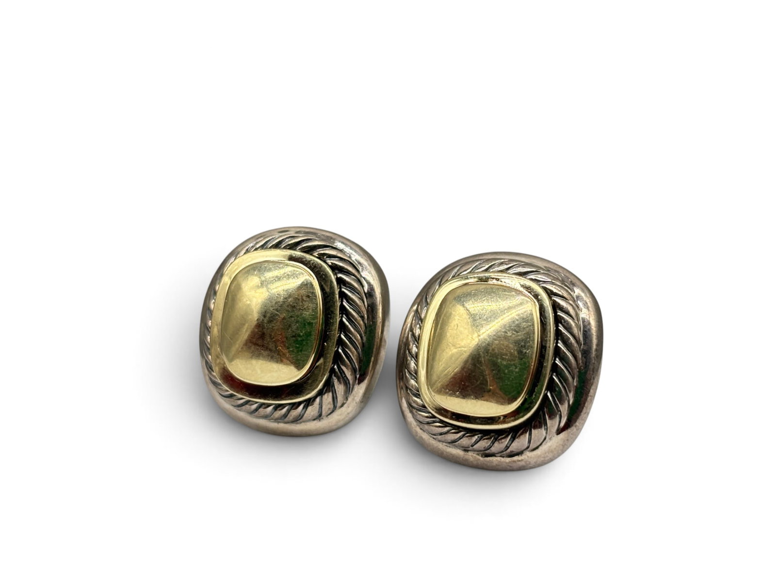 David Yurman 14K and Sterling Albion Dome Earrings: A pair of David Yurman Albion earrings with a two-tone design of a sterling silver cable border with domed 14K cushion-form center. Marked "D.Y.", 585 and 925. 3/4in tall x 5/8in wide. 13.88 dwt. | Yo