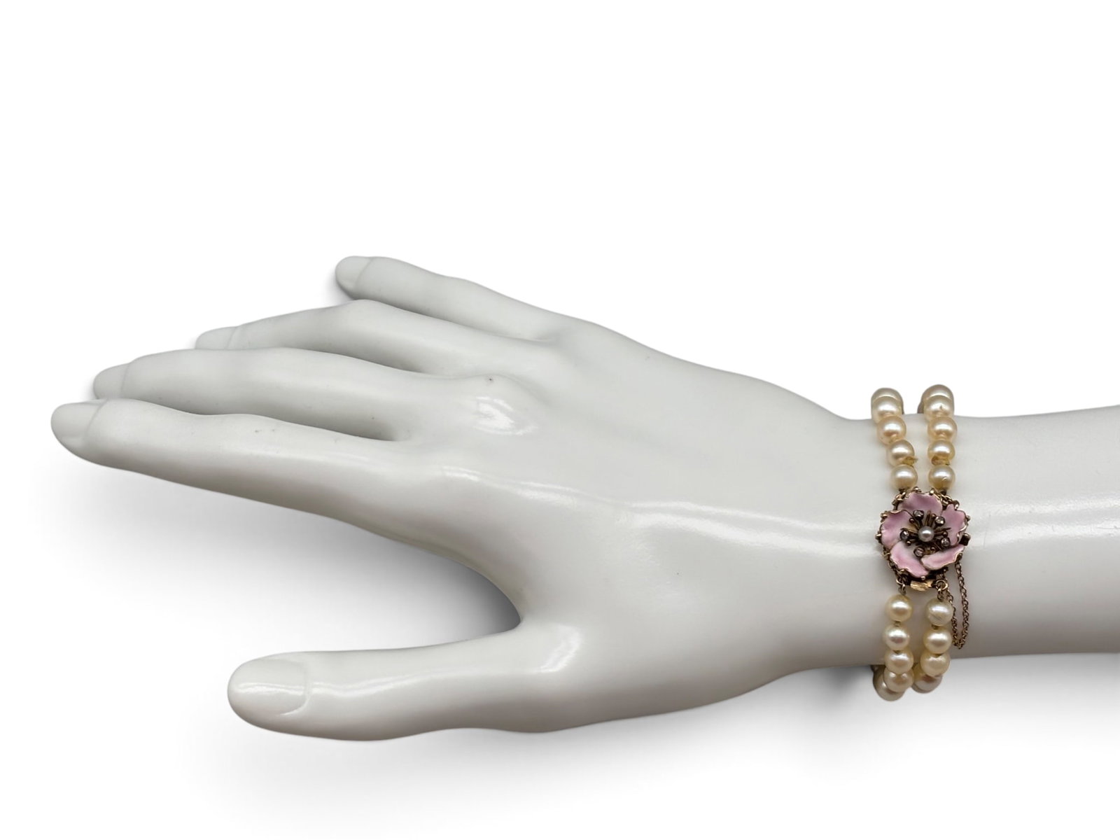 Double-Strand Pearl and Diamond Bracelet: A double-strand pearl bracelet with a 14K yellow gold clasp set with an enameled pink flower with pearl and diamond center. 2-1/2 interior diameter. Tests as 14K. 13.63 dwt. | You have additional ship