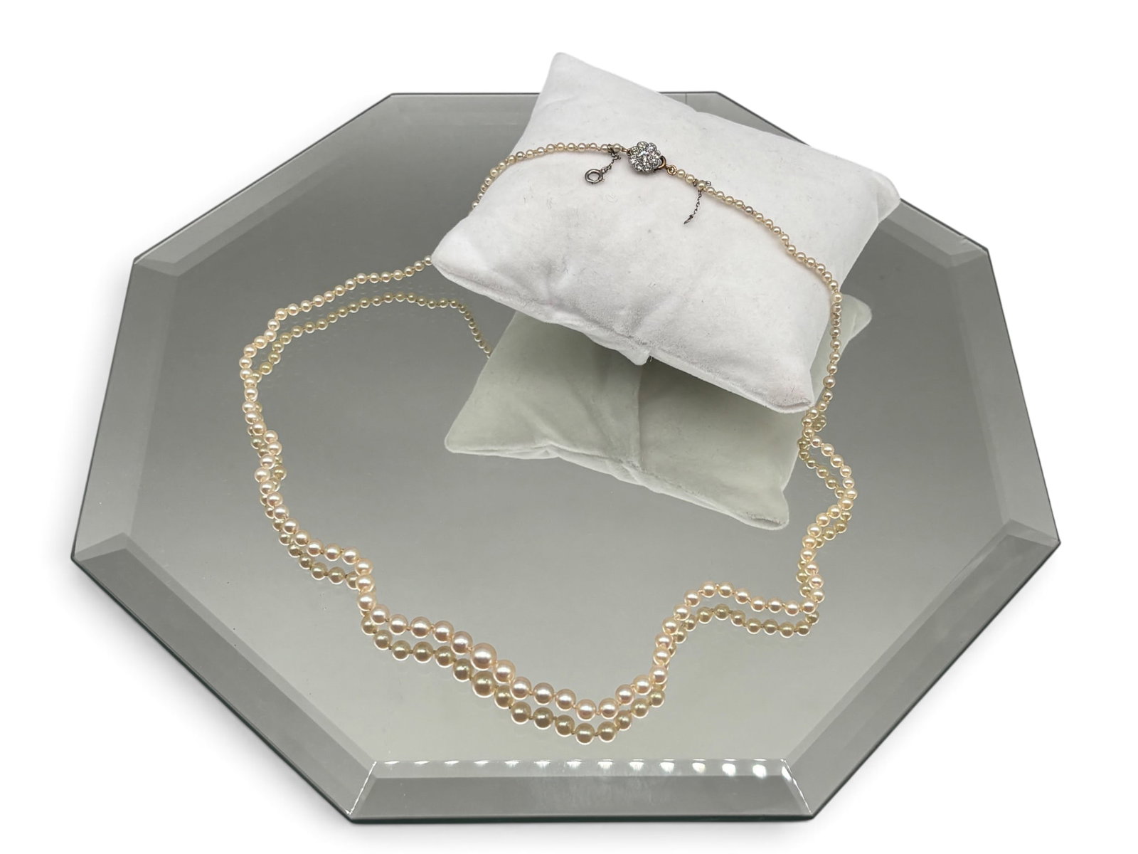 Graduated Pearl Necklace with 14K and Diamond Clasp: A hand-knotted graduated pearl necklace of 2.0 mm-5.2 mm pearls with a 14K yellow and white gold clasp adorned with a flower-form diamond closure featuring a central round diamond surrounded by eight 