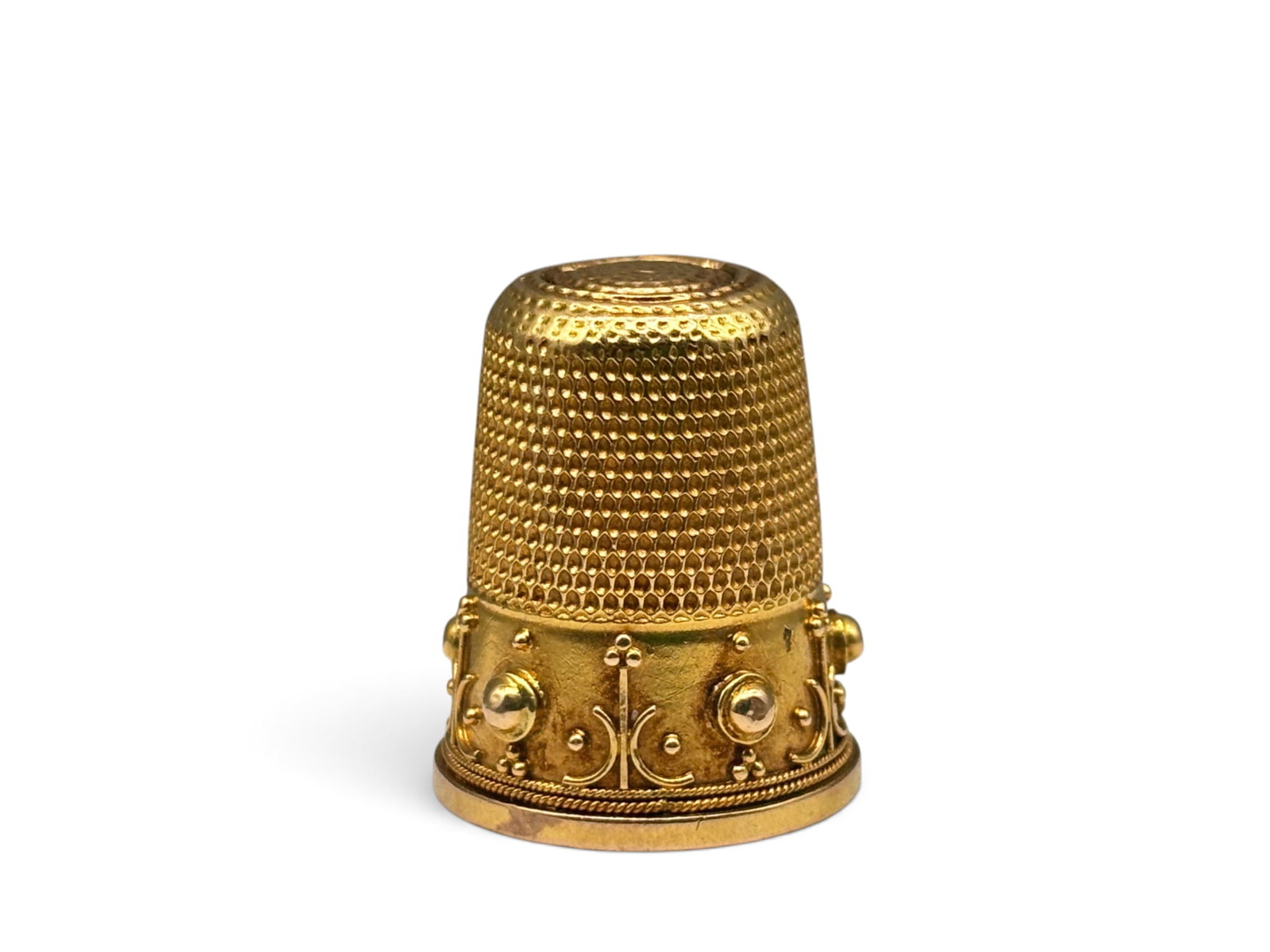 18K Victorian Decorated Thimble: An 18K yellow gold thimble with wide band, applied lines, and beaded texture. Thimble has additional piece of gold in the interior. Tests as 18K. 1in tall x 3/4in wide. 2.76 dwt. | You have additional