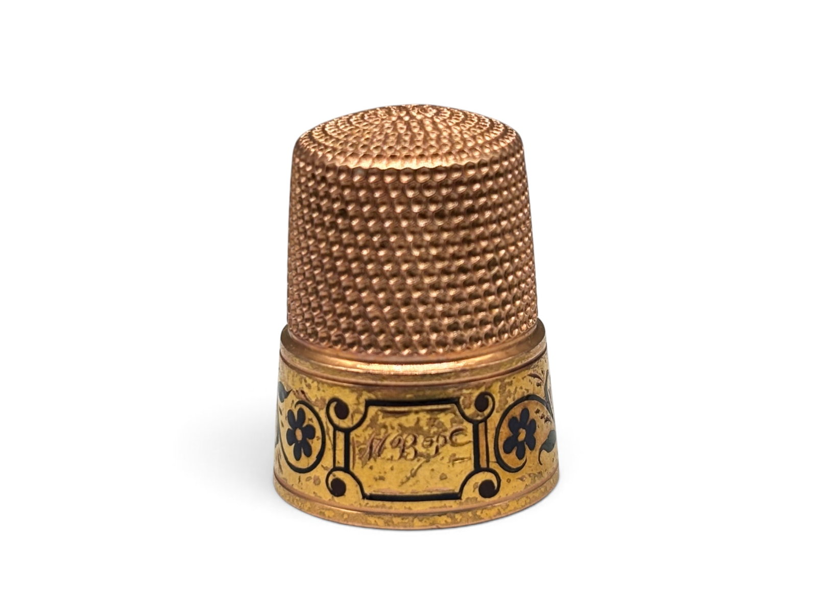 14K Rose Gold and Enamel Thimble: A Victorian 14K rose gold thimble with 18K yellow gold border and black enameled floral design. Engraved "M.B.P." in cartouche. Engraved on interior "From JBP Xmas 1881". Interior is marked 14K. 3/4in