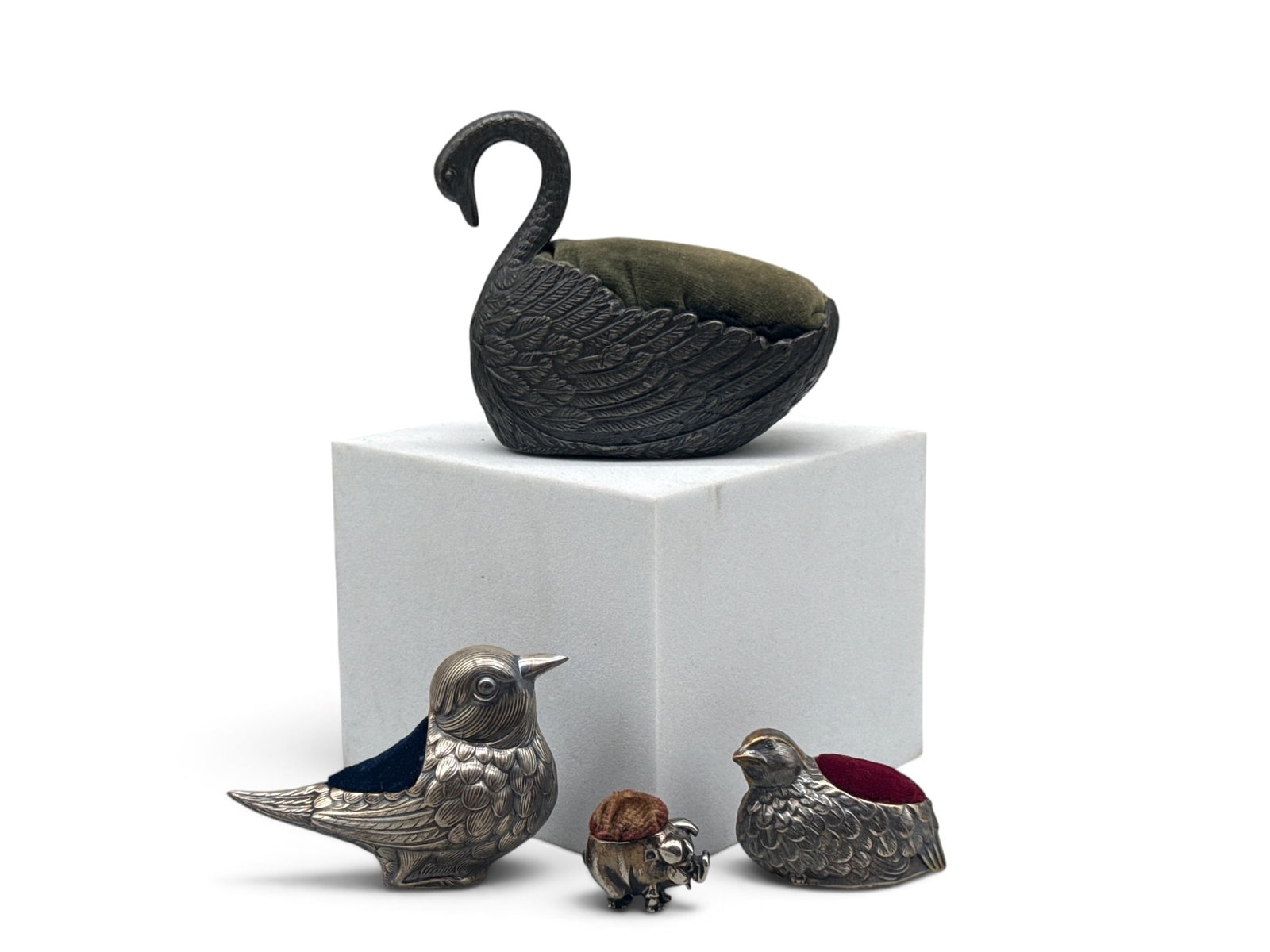 Four Pewter and Sterling Animal Form Pin Cushions: Four animal form pin cushions to include a large pewter Swan with dark green velvet; two small sterling silver bird forms; and a petite sterling silver piglet. Smaller birds are marked 925. Piglet