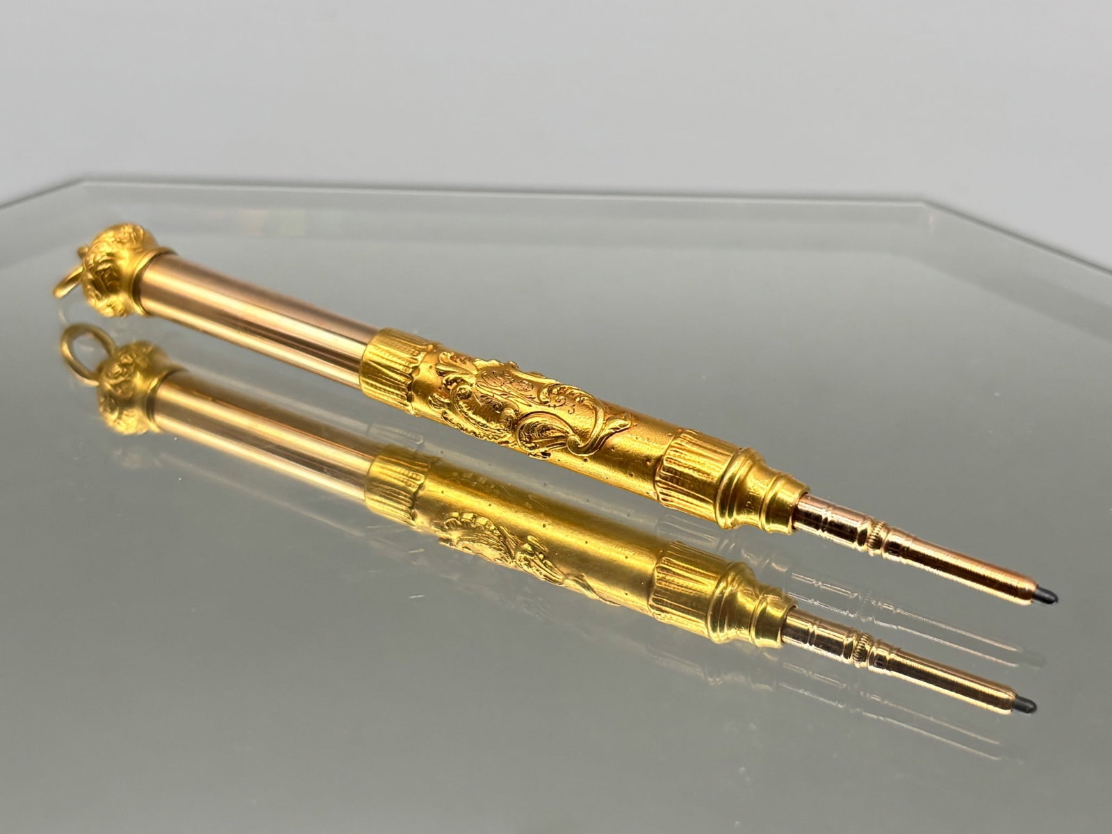 18K Yellow Gold Telescopic Pencil: An 18K yellow gold telescopic pencil pendant with fancily-engraved crest monogram at center and filigree engraved pencil cap. Marked "OP" / 18K. Extended: 3-1/2in; collapsed: 7/8in. 6.62 dwt. | You ha