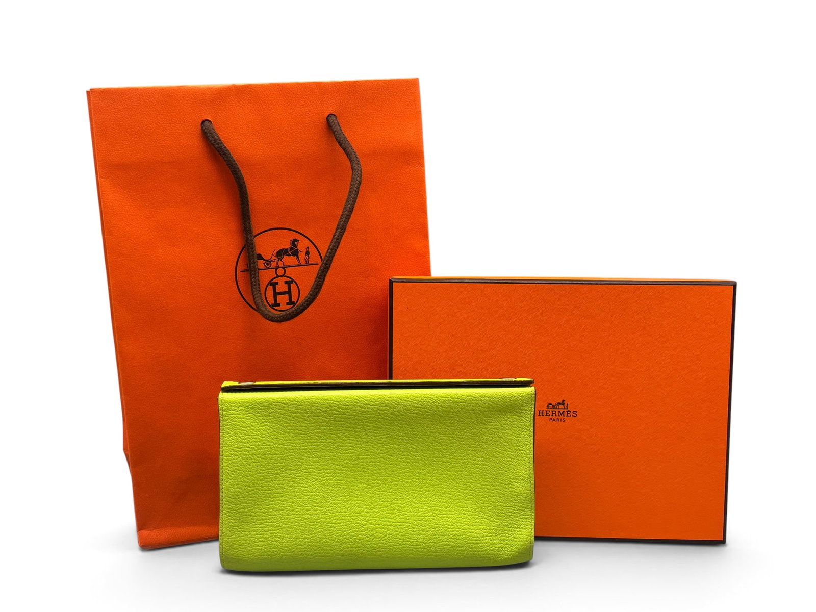Hermes Karo Kiwi Leather Pouch: An Hermes Karo leather pouch in kiwi verte with silver tone snap closure and burgundy interior. Marked Hermes on hardware and on interior. Includes original box and bag. 5-1/2in tall x 7-1/2in wide. |
