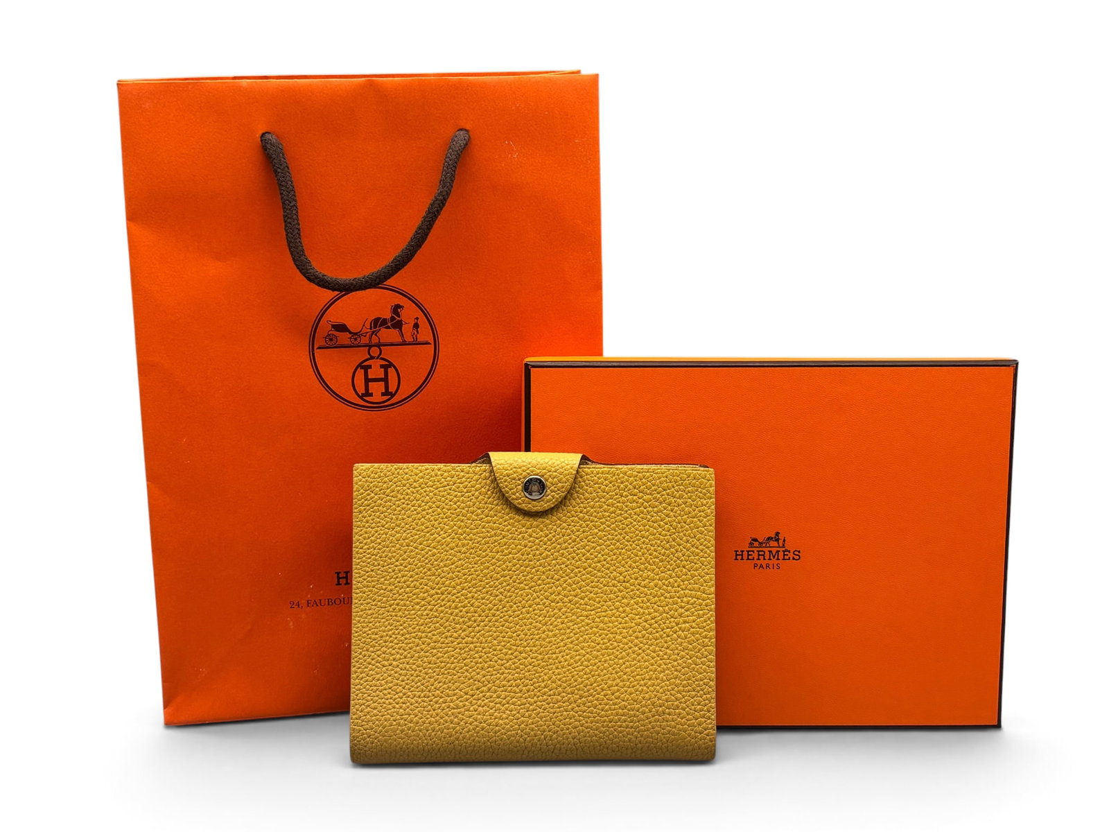 Hermes Ulysse PM Leather Notebook: An Hermes Ulysse PM Togo leather notebook in yellow, with silver tone hardware and Hermes paper on interior. Marked Hermes on hardware and on interior. Includes original box and Hermes shopping bag. 6