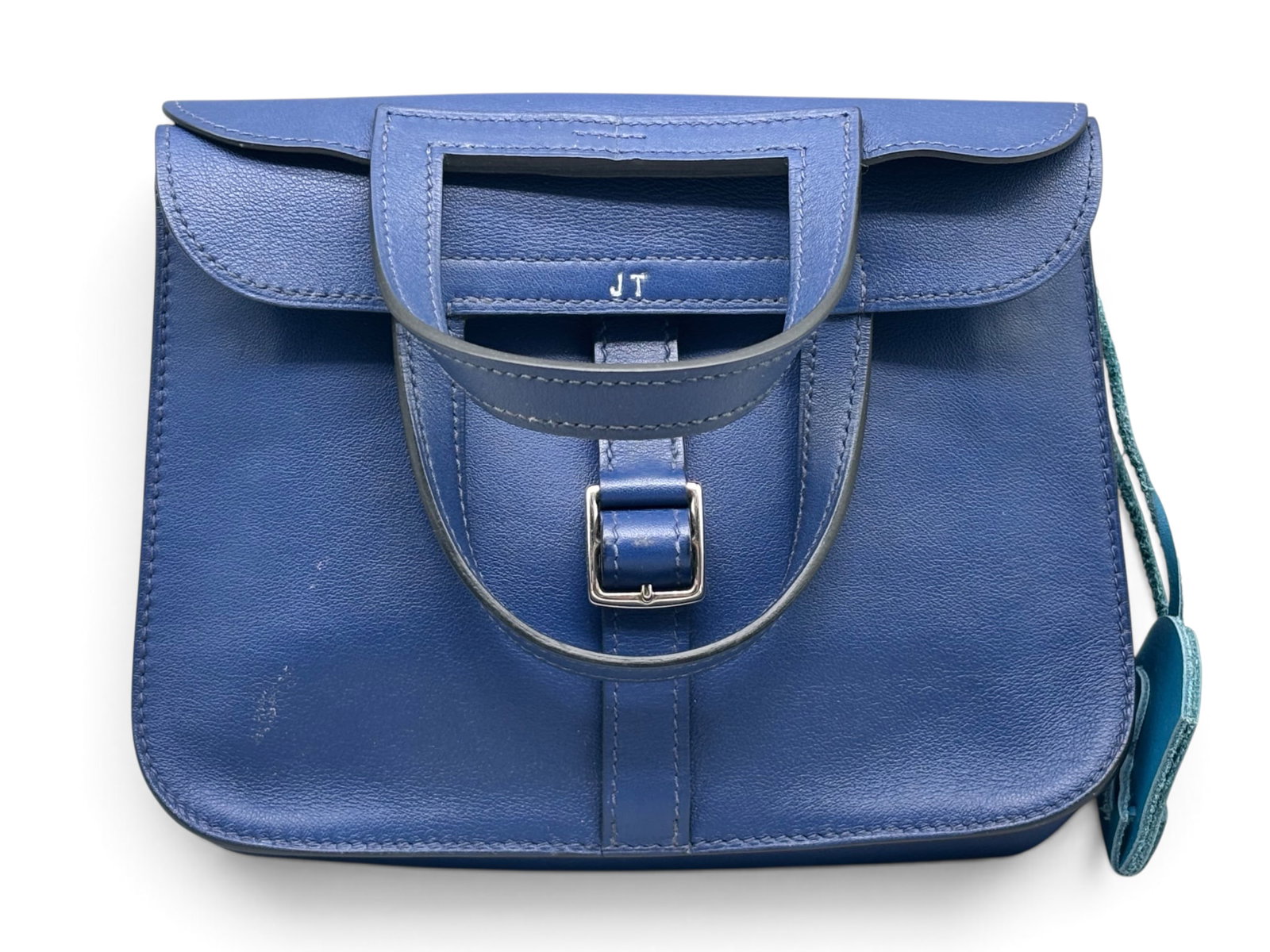 Hermes Halzan Mini Handbag Aj Bleu Saphir: An Hermes Paris Halzan Mini Handbag in Aj Bleu Saphir swift calfskin leather with Etriviere buckle, interior pocket, two front pockets, two back pockets and stirrup-shaped handles. Includes dust cloth