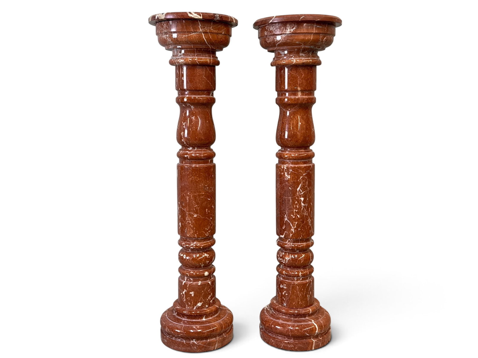 Pair of Rouge Marble Display Pedestals: A pair of turned rouge marble display pedestals, circa 20th C. 47-1/2in tall. Top: 12-1/2in diameter. | You have additional shipping options, and are not required to use Live Shipping. Additional ship