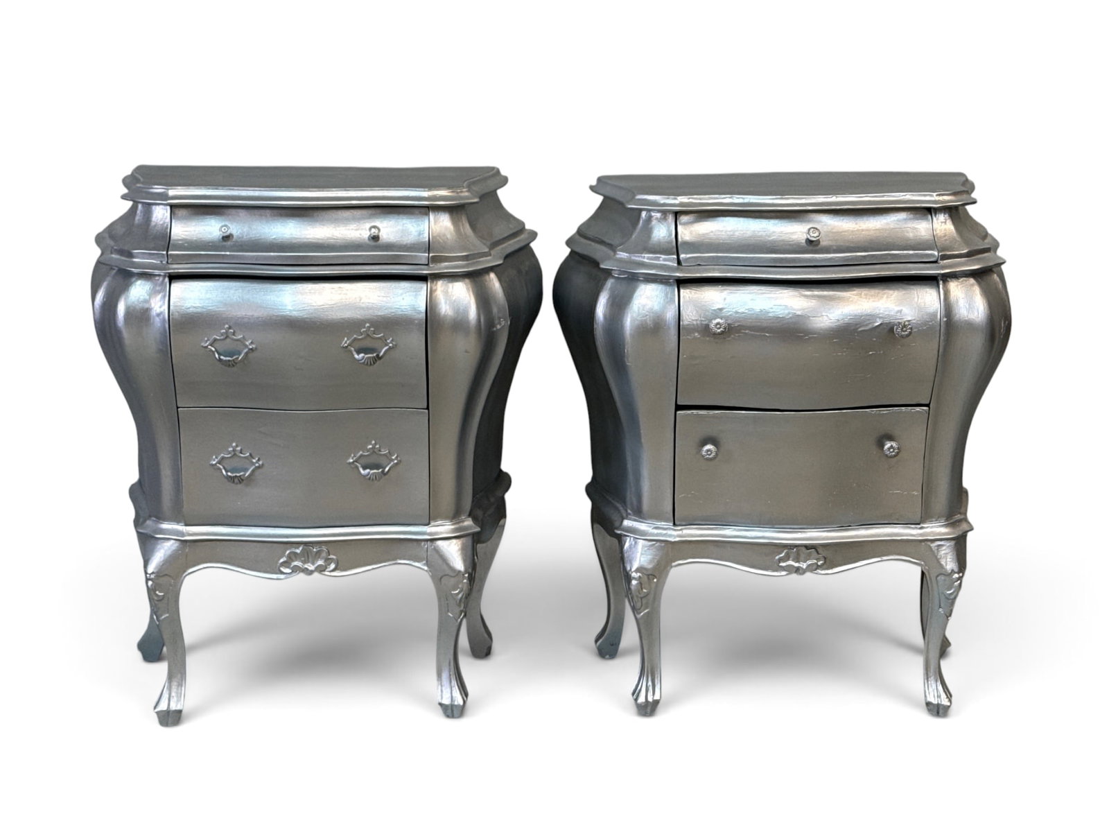 Pair of Silver Painted Bombe Chests: A pair of silver painted bombe chests of three drawers on cabriole legs. Each: 27in tall x 23in wide x 13-1/2in deep. | You have additional shipping options, and are not required to use Live Shipping.