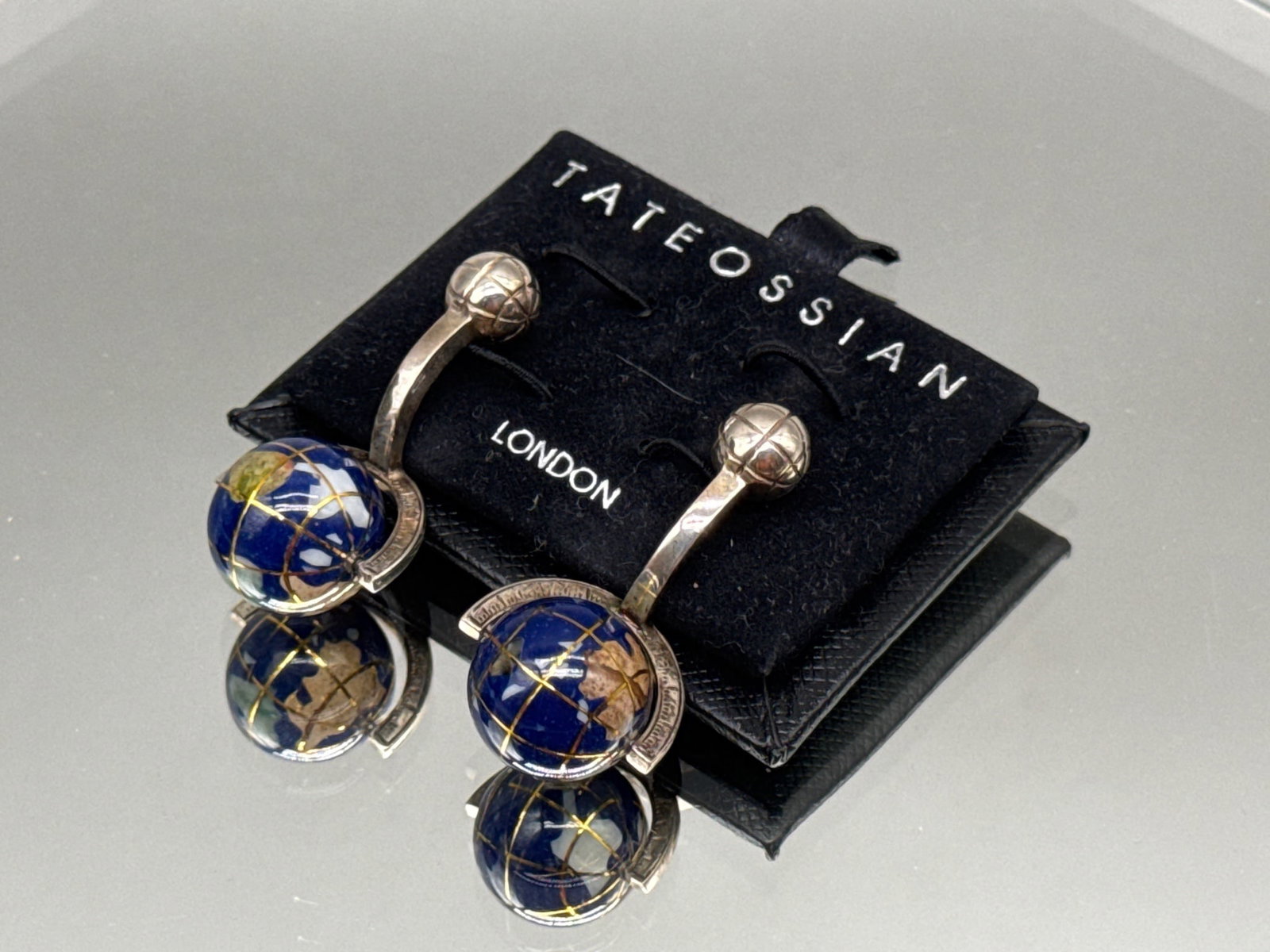 Tateossian Sterling and Lapis Globe Cufflinks: A pair of Tateossian sterling silver and lapis globe-form cufflinks. Hallmarked. Includes original branded display holder. 1in long x 1/2in wide. 10.54 dwt. | You have additional shipping options, and