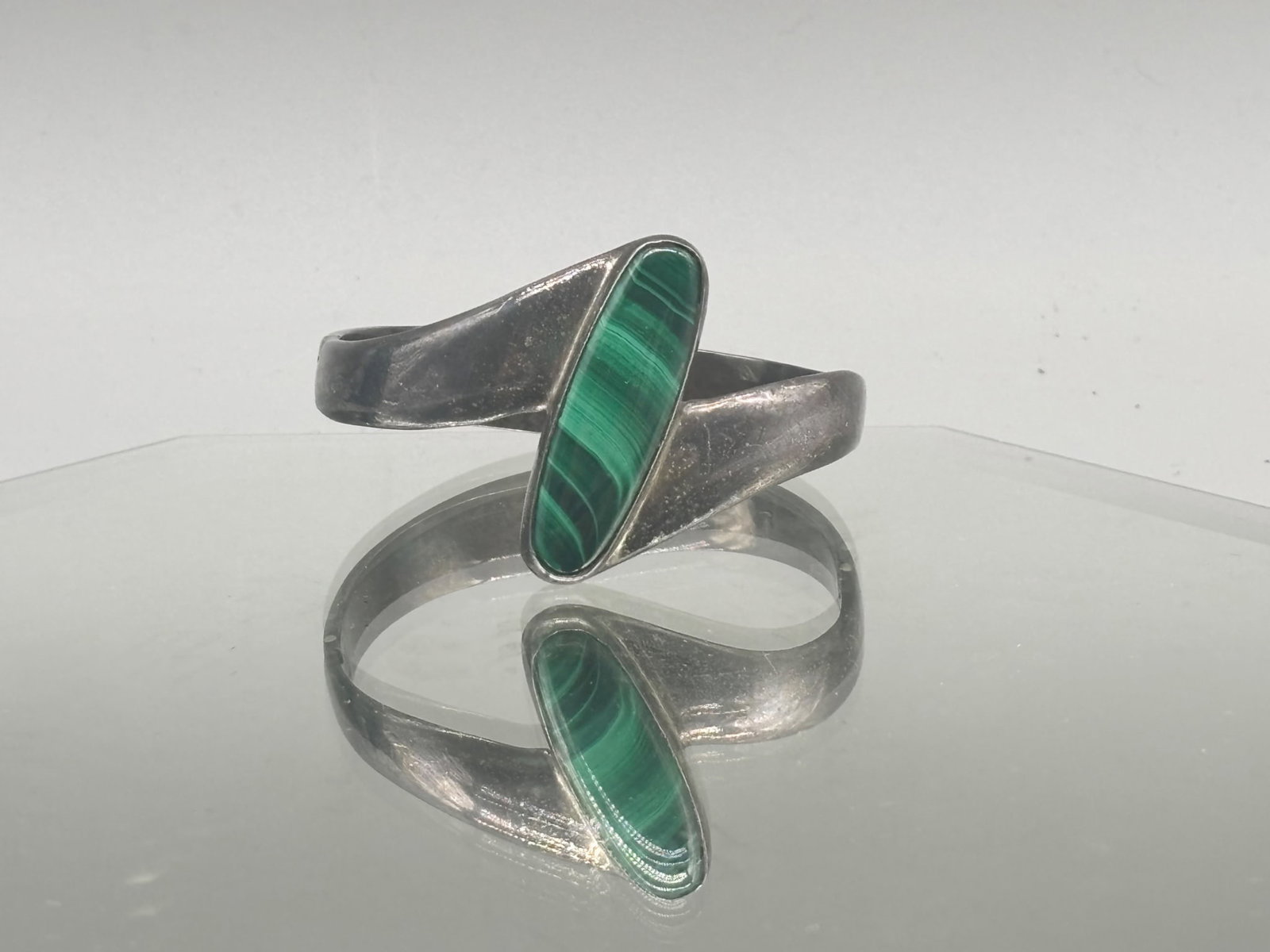 Taxco Sterling Malachite Bracelet: A Taxco Sterling silver bracelet of modernist form with a large oval cut malachite stone. Marked .925 Taxco on interior. 1-1/2in tall x 2-1/4in wide. 36.90 dwt. | You have additional shipping options,