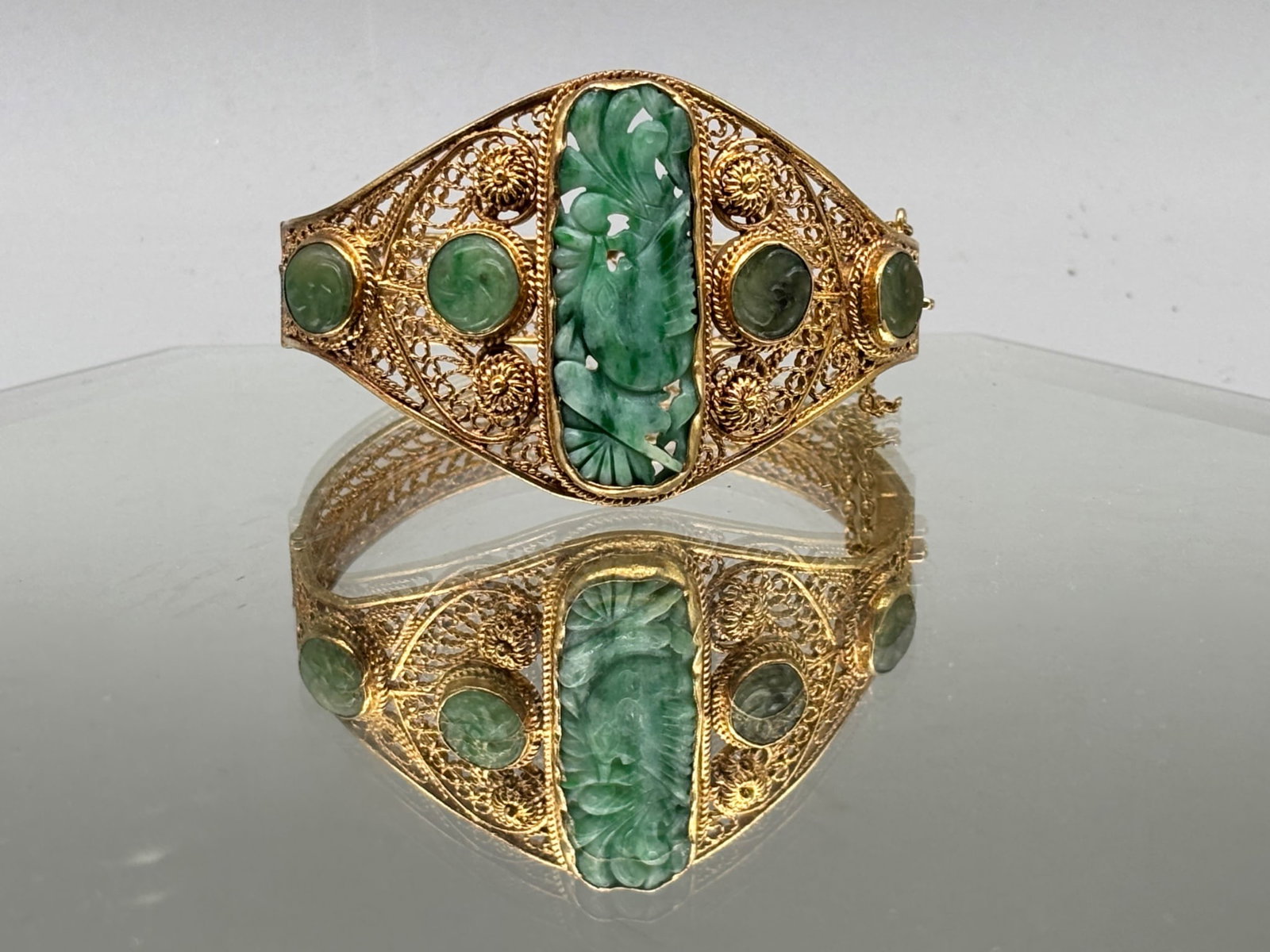 Sterling Silver and Jade Filigree Bracelet: A gold-washed sterling silver filigree bracelet with inset carved jade stones. Marked Sterling. 1-1/4in tall x 2in wide. 24.04 dwt. | You have additional shipping options, and are not required to use 