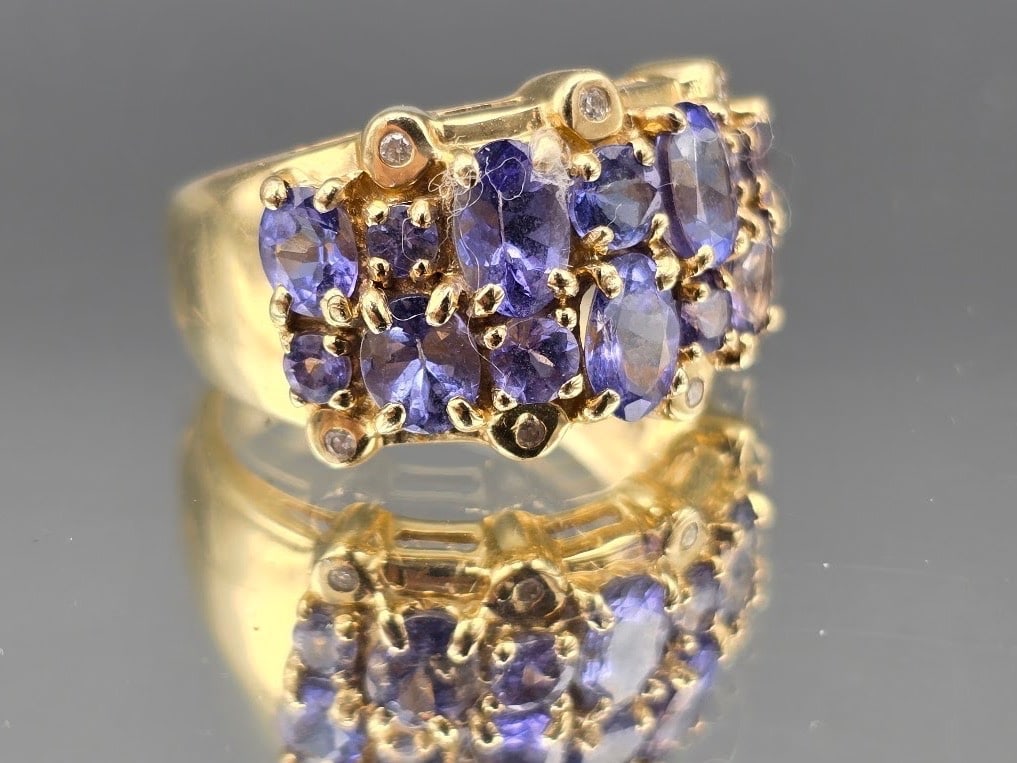 14K Oval Tanzanite Cluster Ring: A 14K yellow gold ring with fourteen oval and circular cut tanzanites surrounded by six small round diamonds. Marked 14K. 7-1/4. 4.30 dwt. | You have additional shipping options, and are not required 
