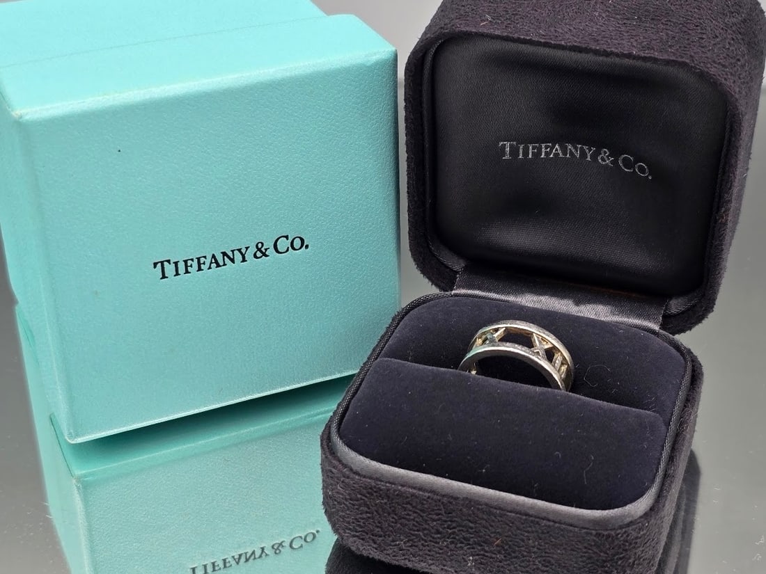 Tiffany & Co. Sterling Silver Atlas Ring: A Tiffany & Co. sterling silver Atlas ring with Roman numeral openwork design. Marked Tiffany & Co. .925 on interior of ring. Includes original ring box and blue Tiffany & Co. box. Size 5.5. 0.15 ozt.