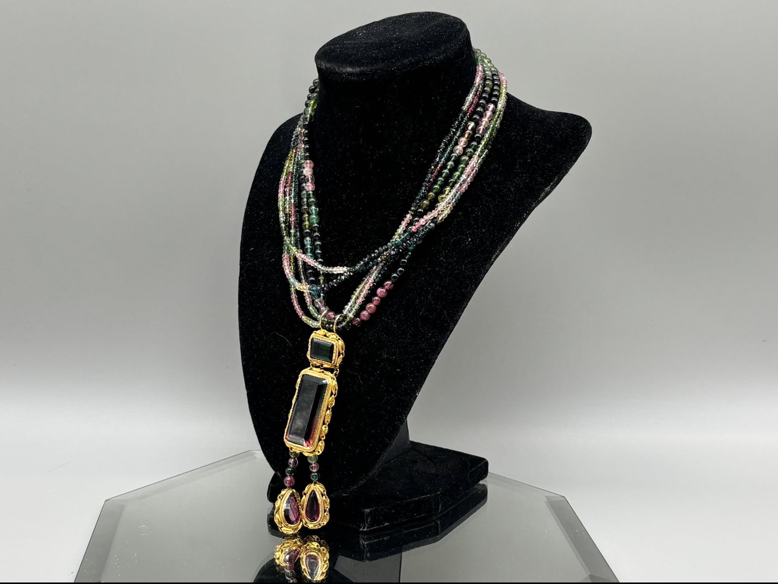 18K Watermelon Tourmaline Pendant: An Art Nouveau-style 18K yellow gold pendant set with a 33ct brilliant cut rectangular watermelon tourmaline topped by a 3.5ct rectangular cut green tourmaline in gold frame, and with two gold-framed 