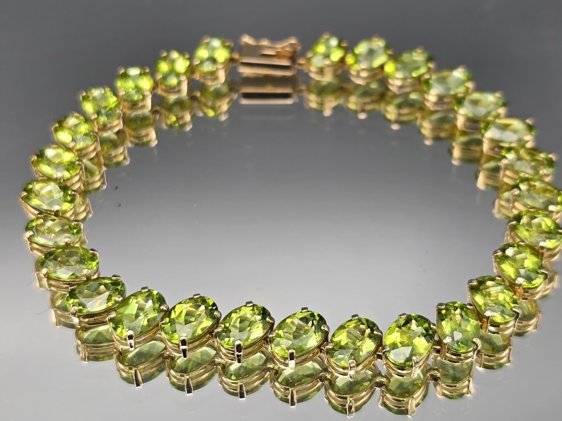 14K Oval Cut Peridot Tennis Bracelet: A 14K yellow gold tennis bracelet with oval cut peridots. Marked 14K. 7in long. 6.43 dwt. | You have additional shipping options, and are not required to use Live Shipping. Additional shipping and del