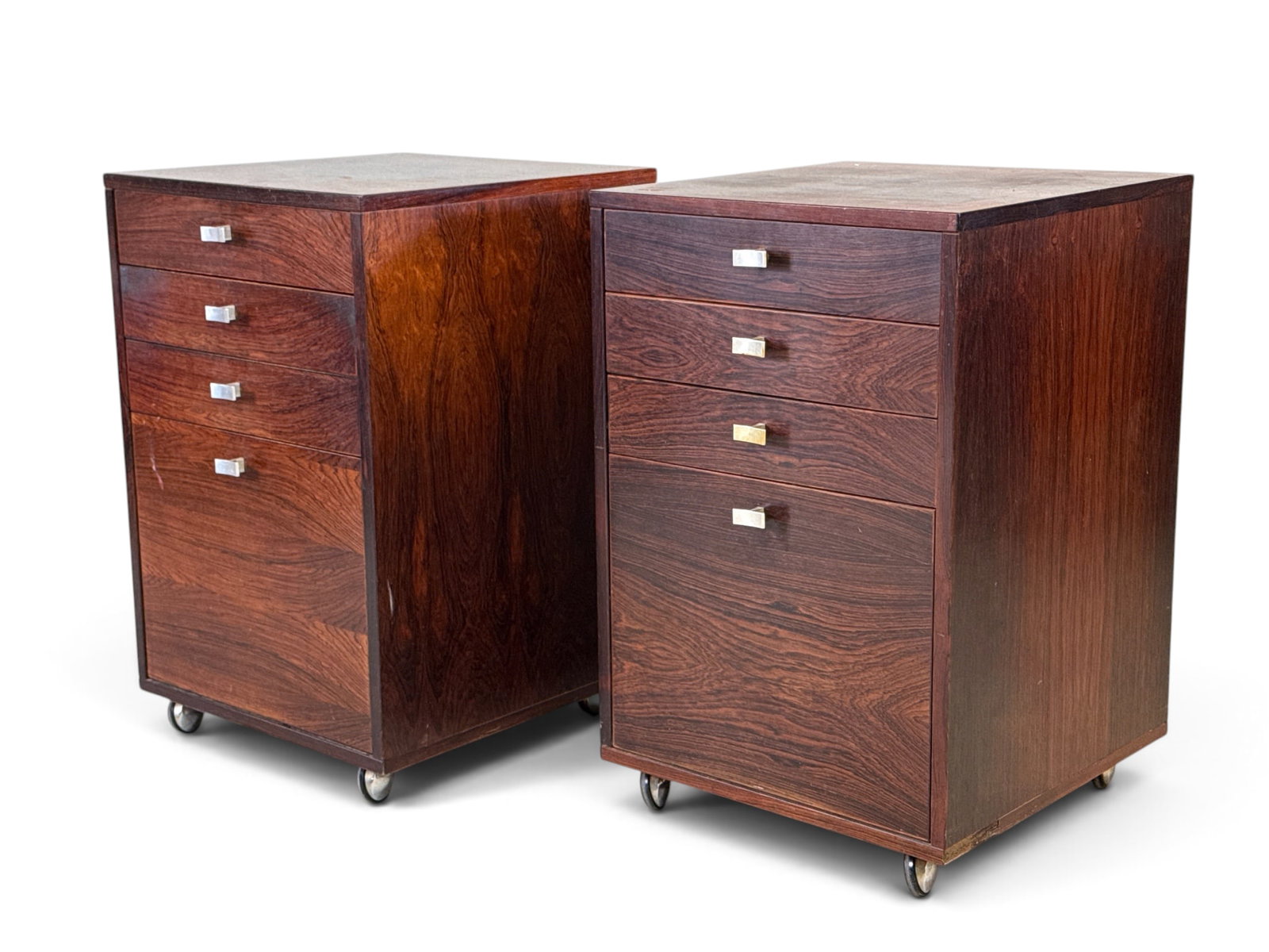 Pair of Peter Lovig Danish Rosewood Side Cabinets: A pair of Peter Lovig Danish rosewood side cabinets with drawers and chrome pulls. Raised on casters. One with label verso. 26-1/4in tall x 17in wide x 18-3/4in deep. | You have additional shipping