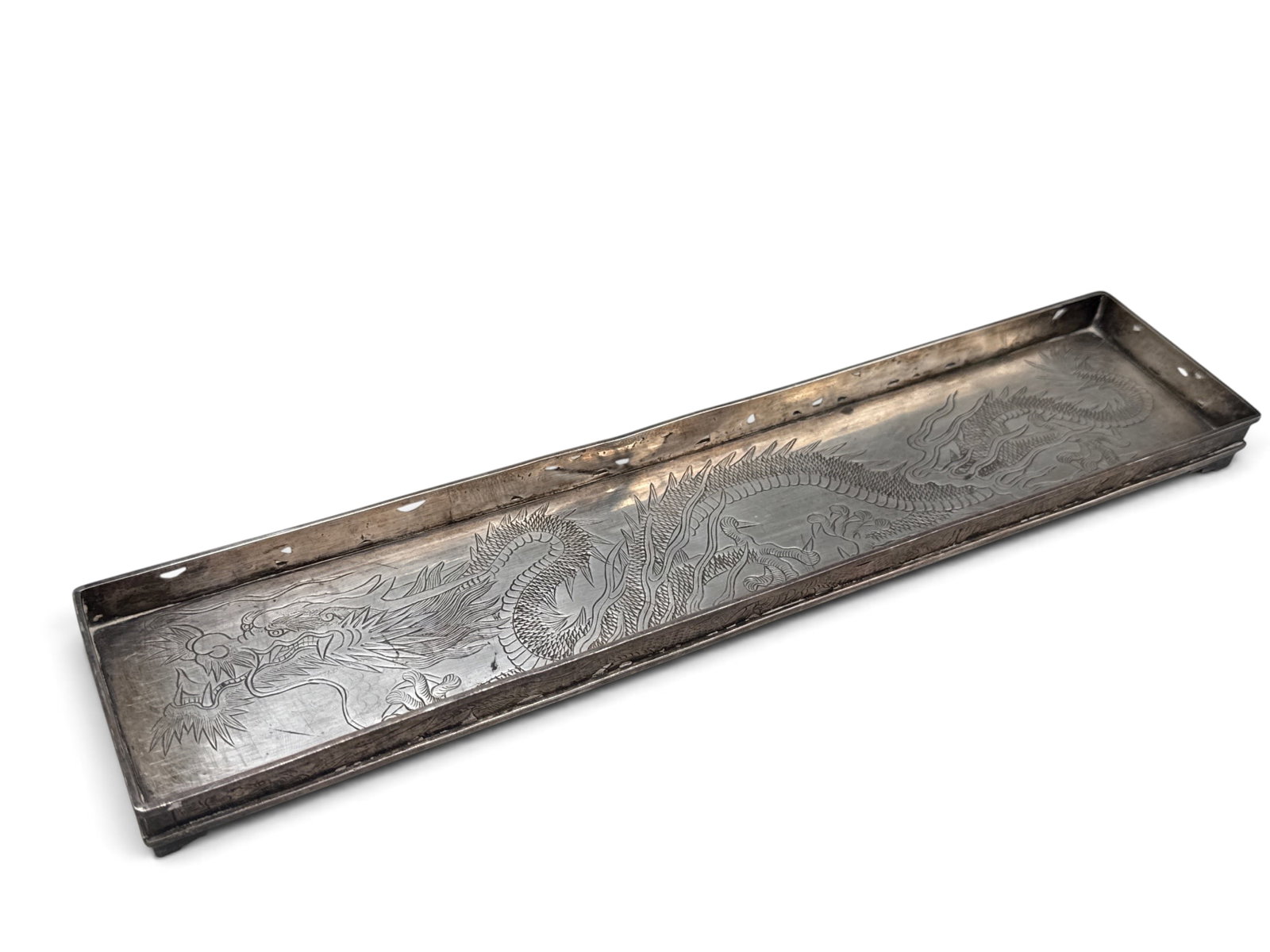 Chinese Export Wang Hing Co. Sterling Pen Tray: A Chinese Export Wang Hing Co. sterling silver pen tray with chased dragon border and engraved dragon motif. Hallmarked and monogrammed underneath. 1/2in tall x 12in wide. 7.01 ozt. | You have