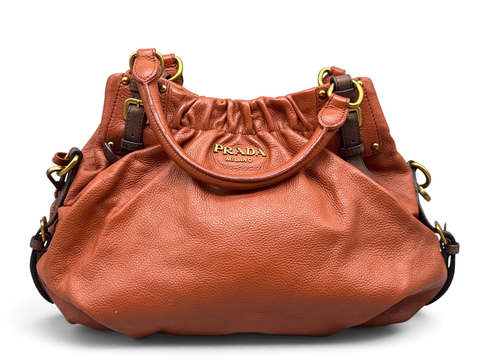 Prada Cognac Calfskin Handbag: A Prada cognac-hued calfskin handbag with dark brown leather buckles and gold tone hardware. Interior Prada tag. 9in tall x 16in wide. | You have additional shipping options, and are not required to