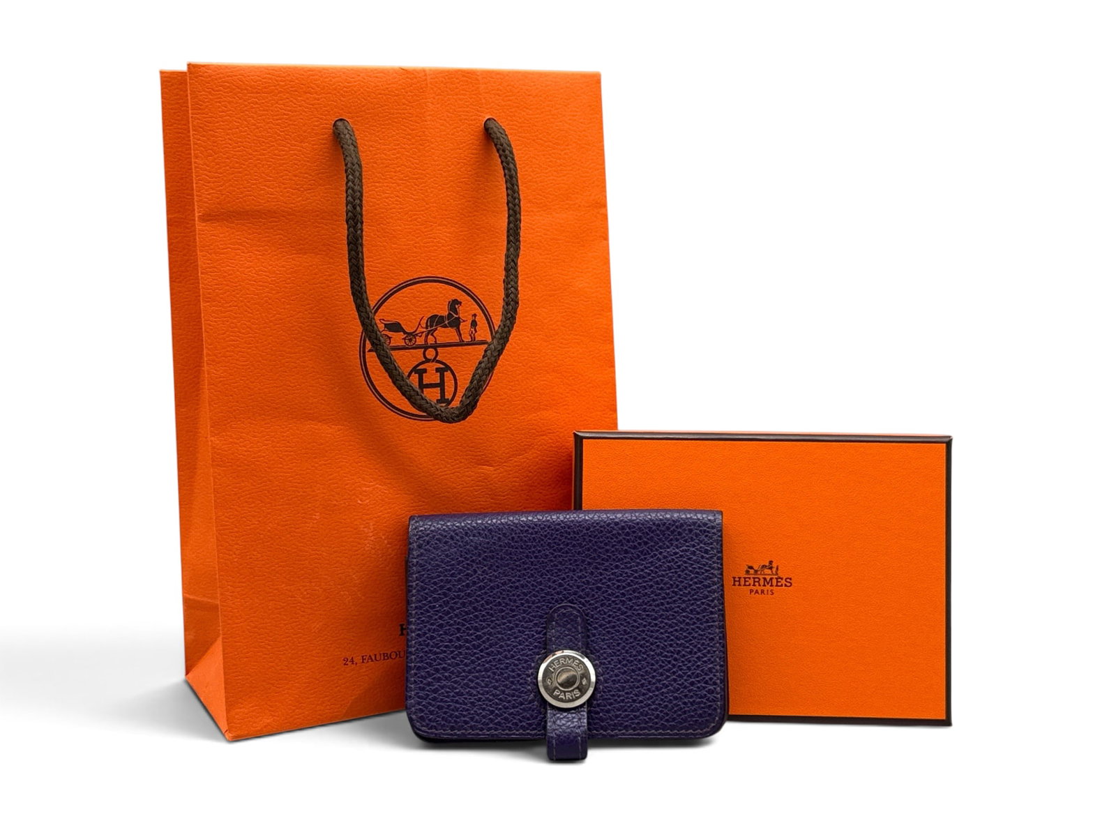 Hermes Togo Leather Dogon Wallet: An Hermes Dogon wallet in purple, pebbled Togo leather with silver-tone hardware. Marked Hermes on hardware and on interior. Includes Hermes original box and bag. Wallet: 3in tall x 4in wide. | You ha