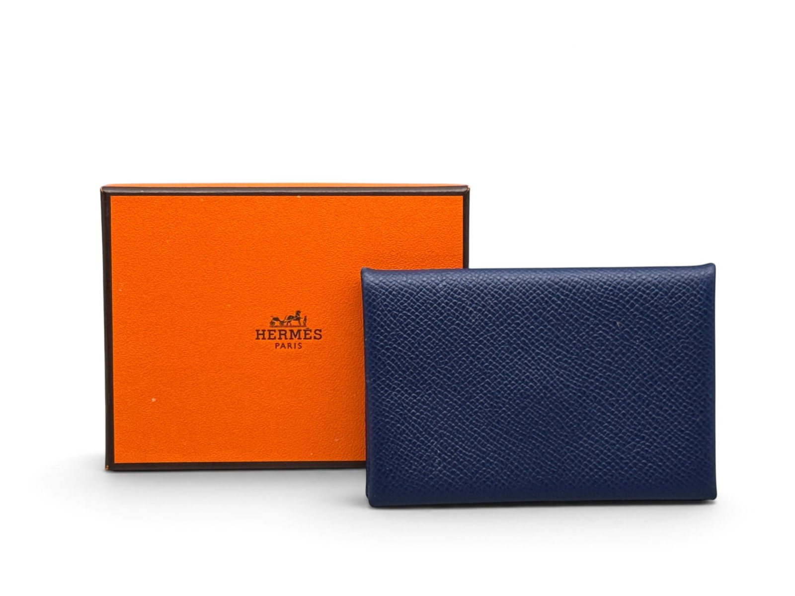 Hermes Navy Calvi Card Holder: An Hermes Calvi card holder in navy epsom calfskin. Marked Hermes on interior. Includes Hermes box. 4.1in tall x 2.8in wide. | You have additional shipping options, and are not required to use Live Sh