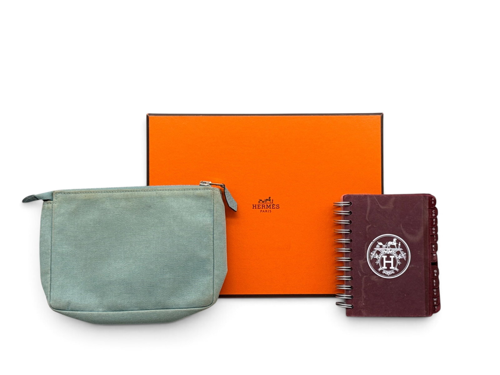Hermes Canvas & Leather Wallet and Address Book: An Hermes light blue canvas wrist wallet with leather straps, marked Hermes on the interior, and an Hermes address book. Includes Hermes box for the wrist wallet. 4-1/2in tall x 6-1/2in wide. | You ha