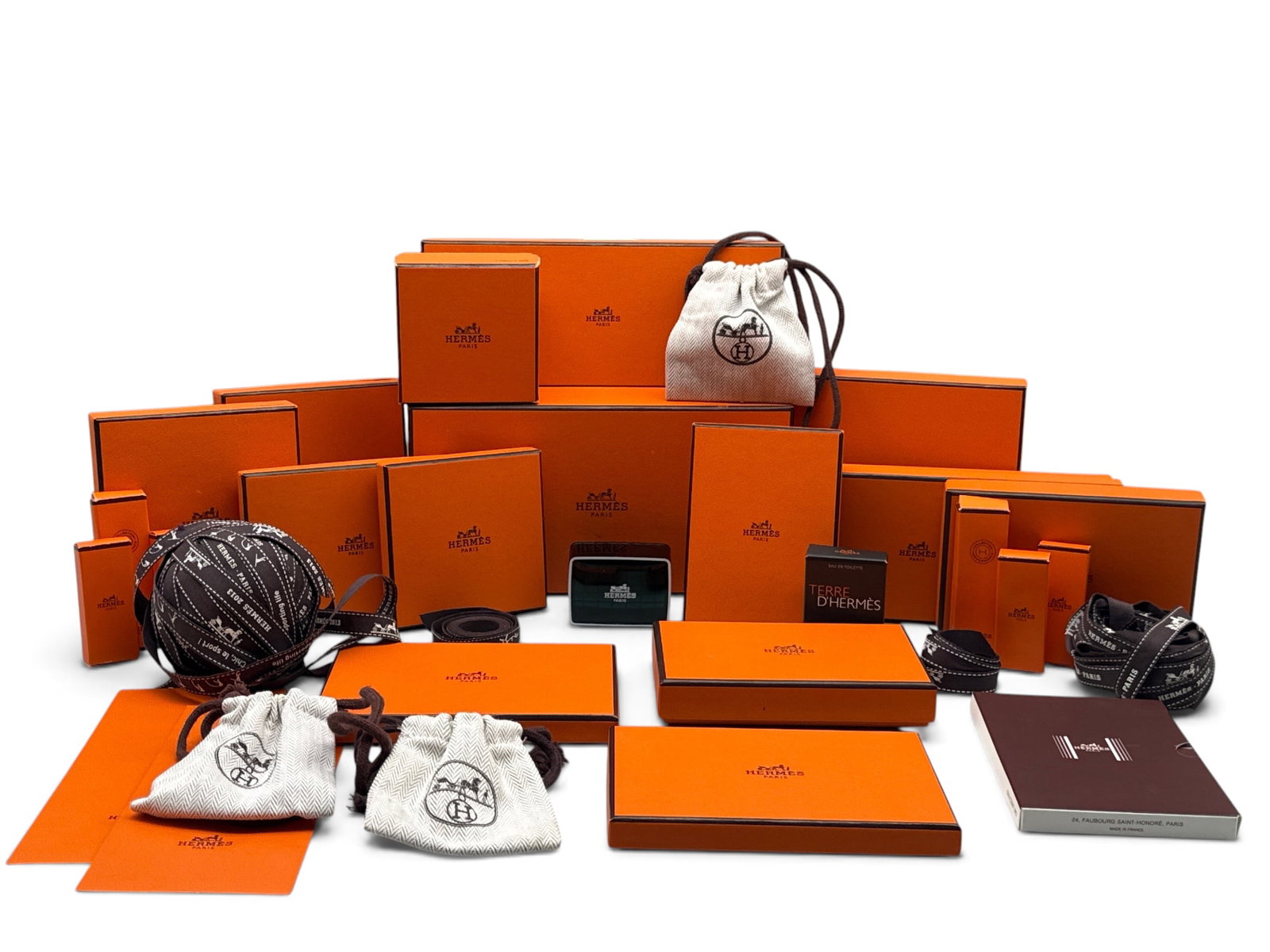 Hermes Paris Gift Boxes and Ribbons: A collection of fourteen Hermes Paris gift boxes, ribbons, three herringbone pouches, an Hermes soap box, a new-in-box Terre D'Hermes eau de toilet, and six boxed perfume samples. Largest box: 5in tal