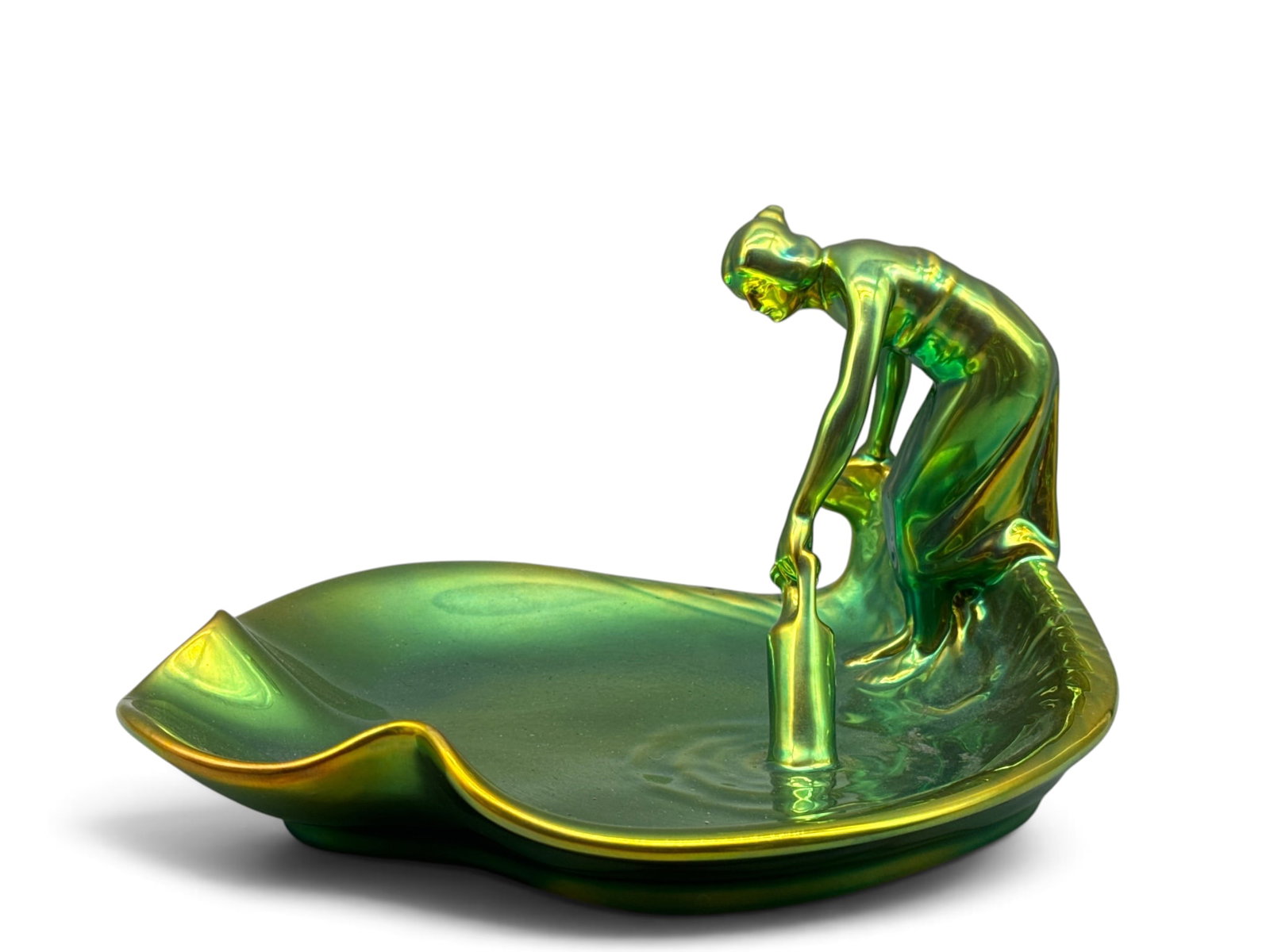 Zsolnay Eosin Iridescent Figural Dish: A Zsolnay Eosin of Hungary porcelain dish with green iridescent finish, depicting a woman taking water from a pond. Signed, impressed number 8. 7in tall x 12in wide. | You have additional shipping