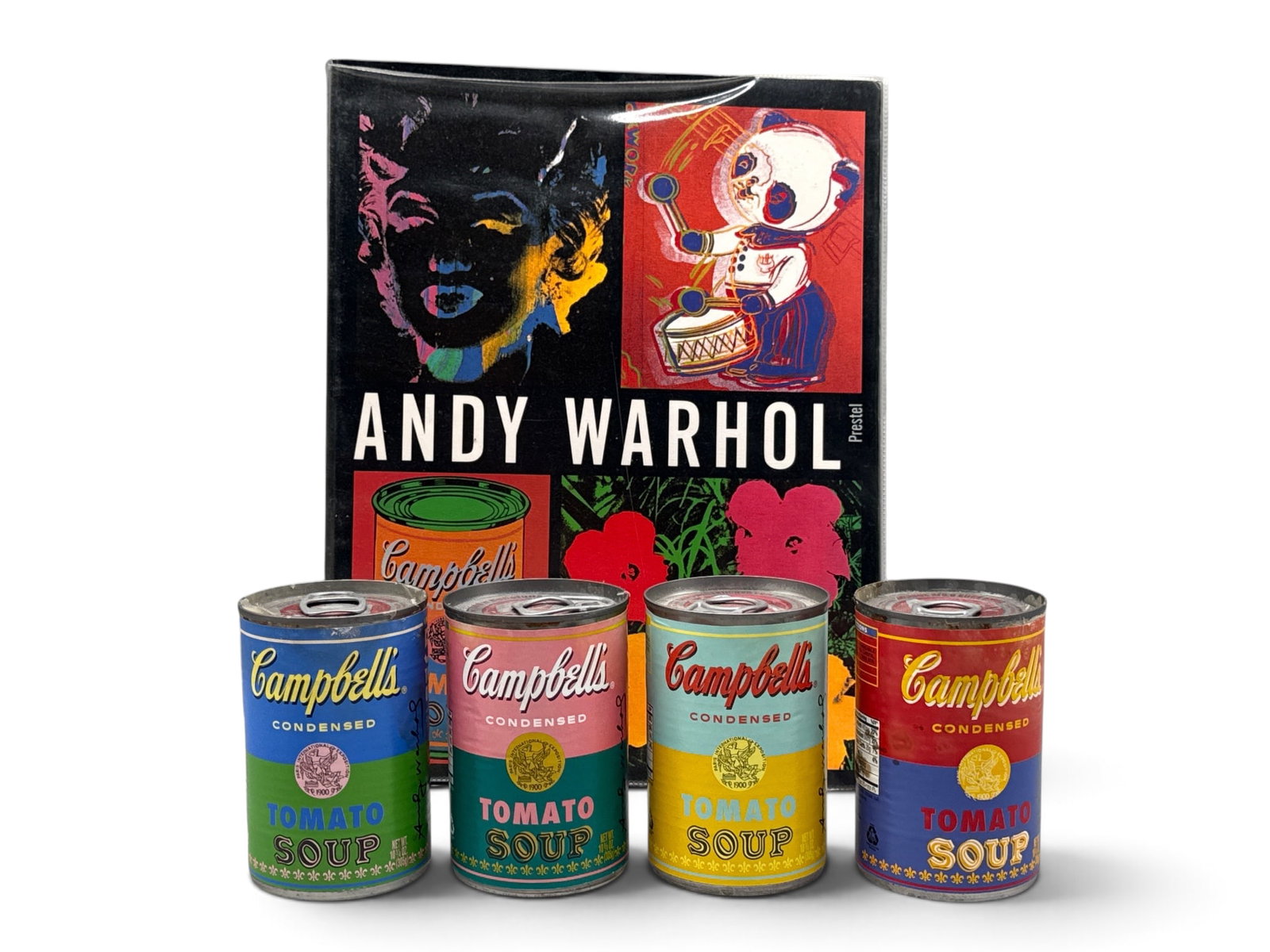 Andy Warhol: Four Campbell's Soup Cans and Book: Circa 2012, "50 Years / The Art of Soup", a limited edition to mark the 50th Anniversary of Andy Warhola's 1962 iconic silk-screen, "32 Campbell's Soup Cans". Comprised of four various colored Tomato 