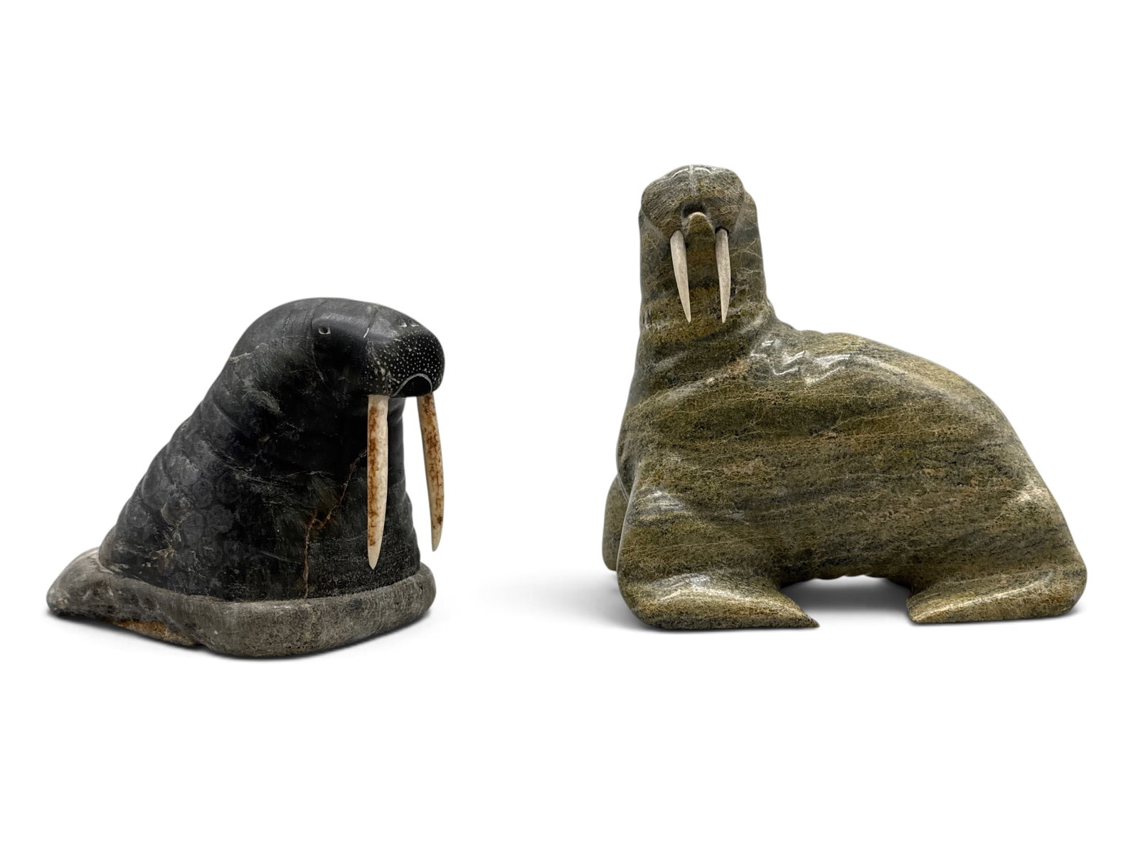 Two Inuit Carved Stone Walrus Figures: Two Inuit carved sculptures of walruses. One signed illegibly. The smaller signed by Jacob Shaimaiwk. Taller: 6-3/4in tall x 7in wide. | You have additional shipping options, and are not required to u