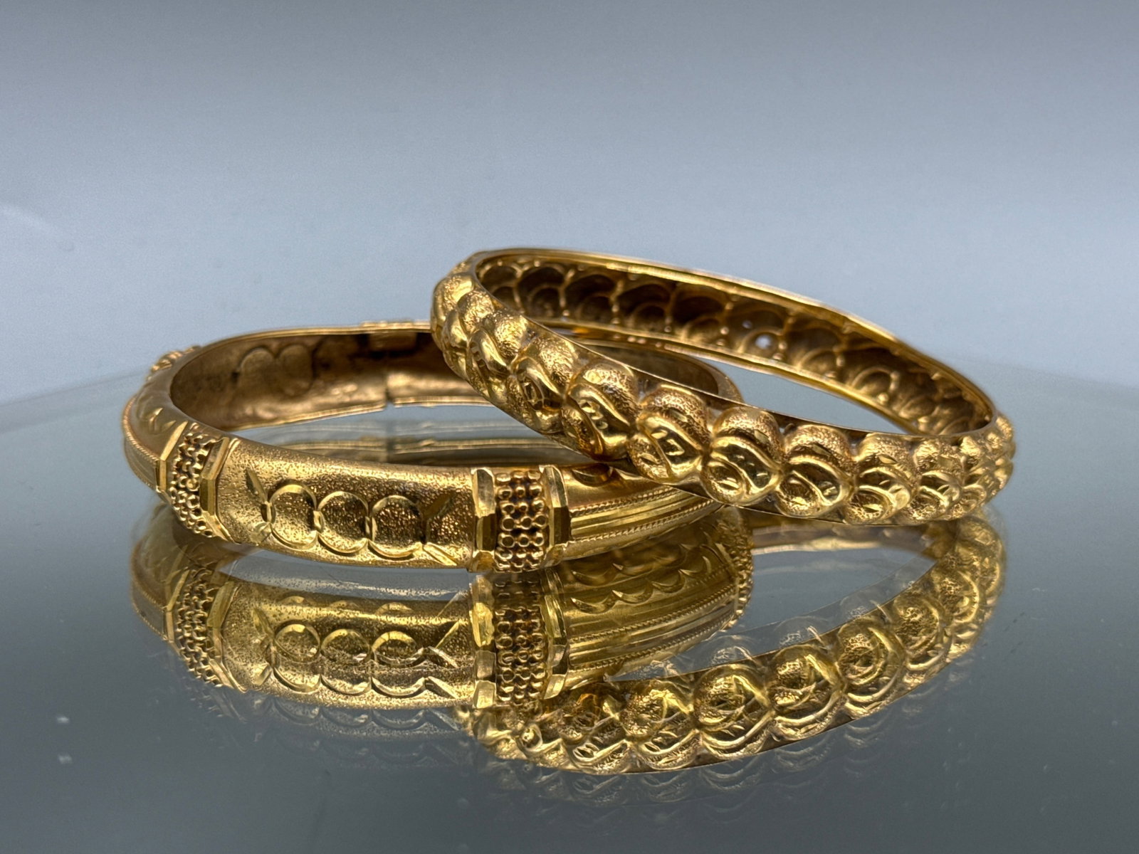 Two 22K Raised Pattern Bangle Bracelets: Two 22K yellow gold bangle bracelets with raised relief patterns. Tests as 22K. Interior diameter: 2-1/2in. 20.44 dwt. | You have additional shipping options, and are not required to use Live Shipping