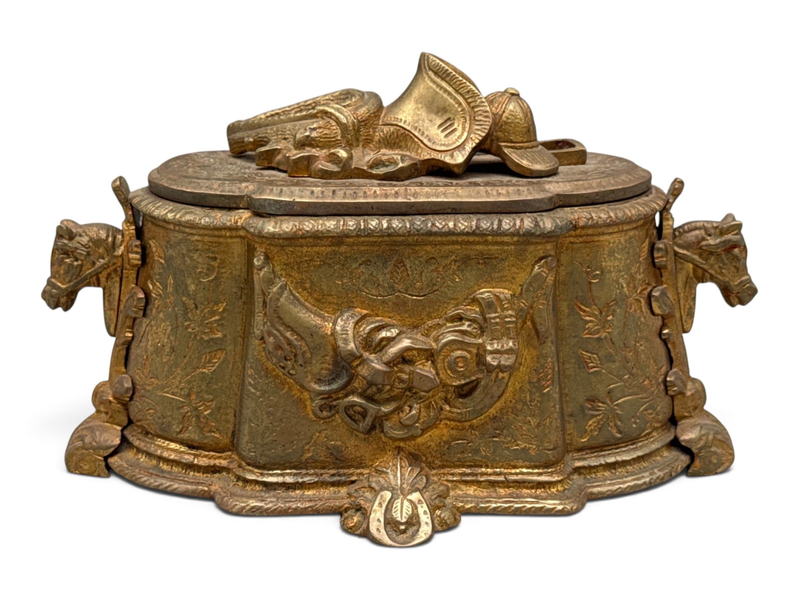 Gilt Metal Equestrian Casket Box: A gilt-painted white metal equestrian casket box with horse-head figural handles and bridle and equestrian accessory-decorated lid. Interior is lined in red velvet. 6in tall x 8in wide. | You have add