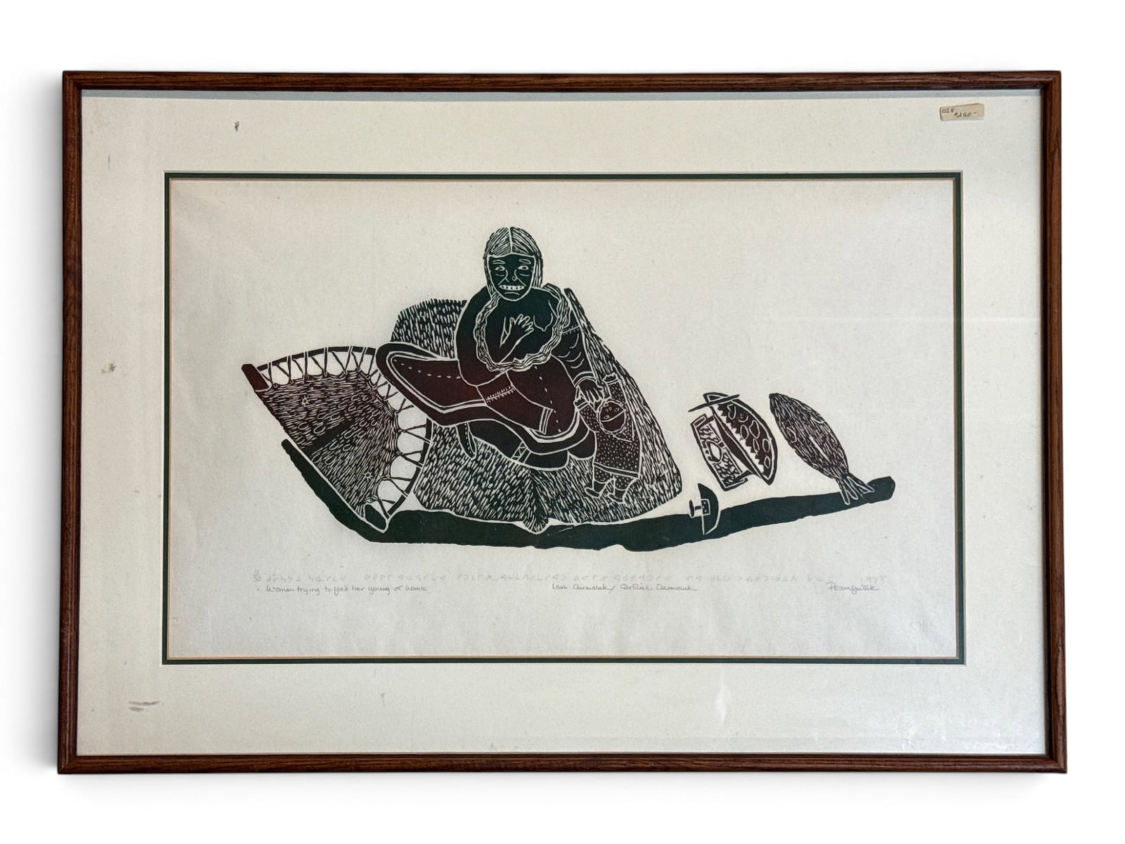 Leah Qumaluk Stone Cut Print: Woman and Children: Leah Qumaluk (Quebec, 1934-2010). A stone cut print titled "Woman Trying to Feed her Young at Home." Pencil signed and titled. Frame: 20in x 29in. Mat opening: 14in x 24in. | You have additional