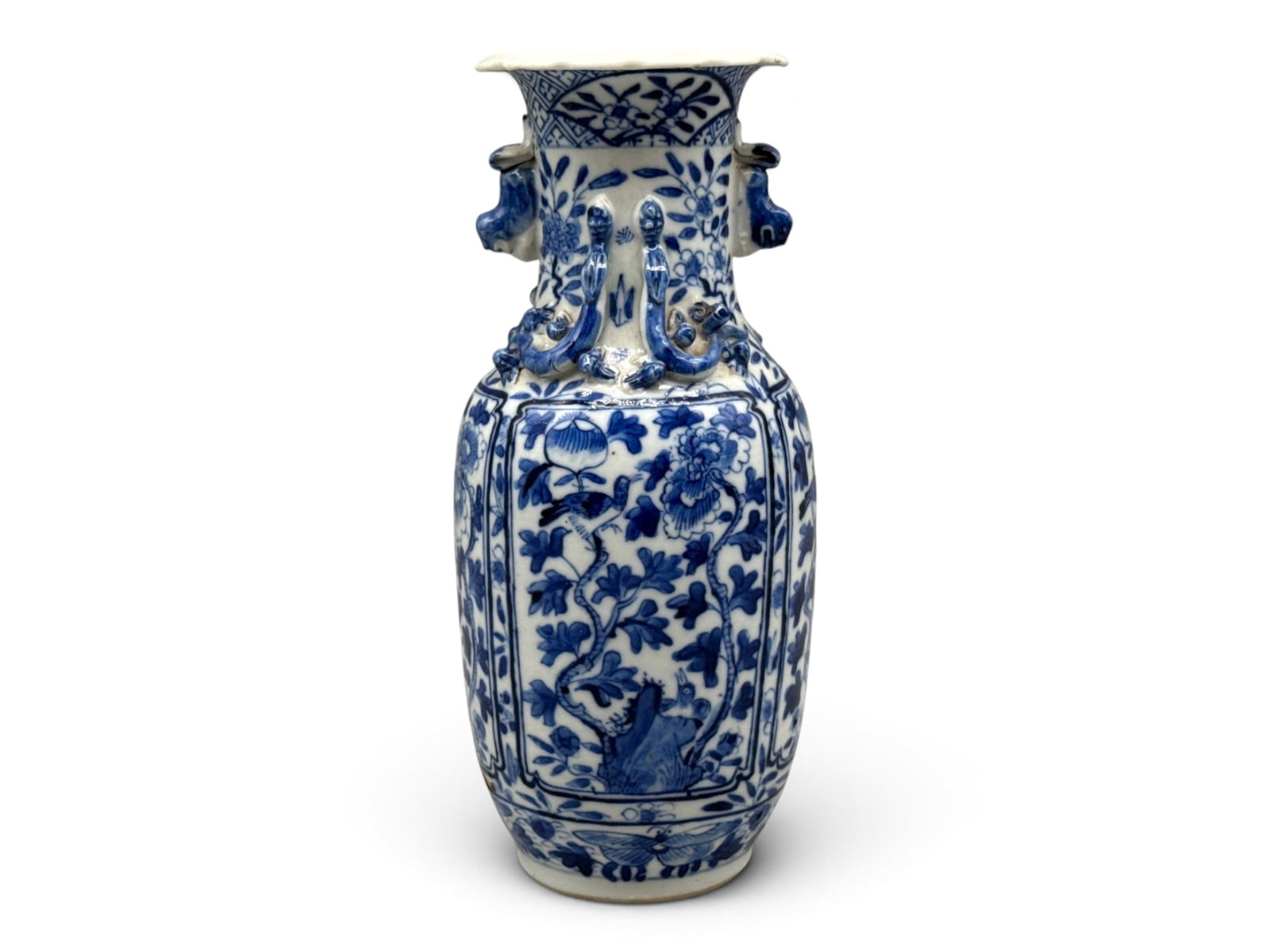 Chinese Blue & White Diminutive Vase: A Chinese blue and white diminutive vase with botanical motif, dog-form handles, and scalloped rim. Kangxi four character mark. 8in tall x 4in wide. | You have additional shipping options, and are not