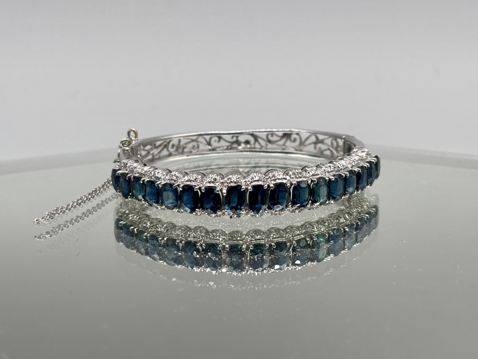 9K Art Deco-style Bangle Bracelet: A 9K white gold Art Deco-style bangle bracelet with oval cut sapphires surrounded by diamonds. 11.18 dwt. 2in diameter. | You have additional shipping options, and are not required to use Live
